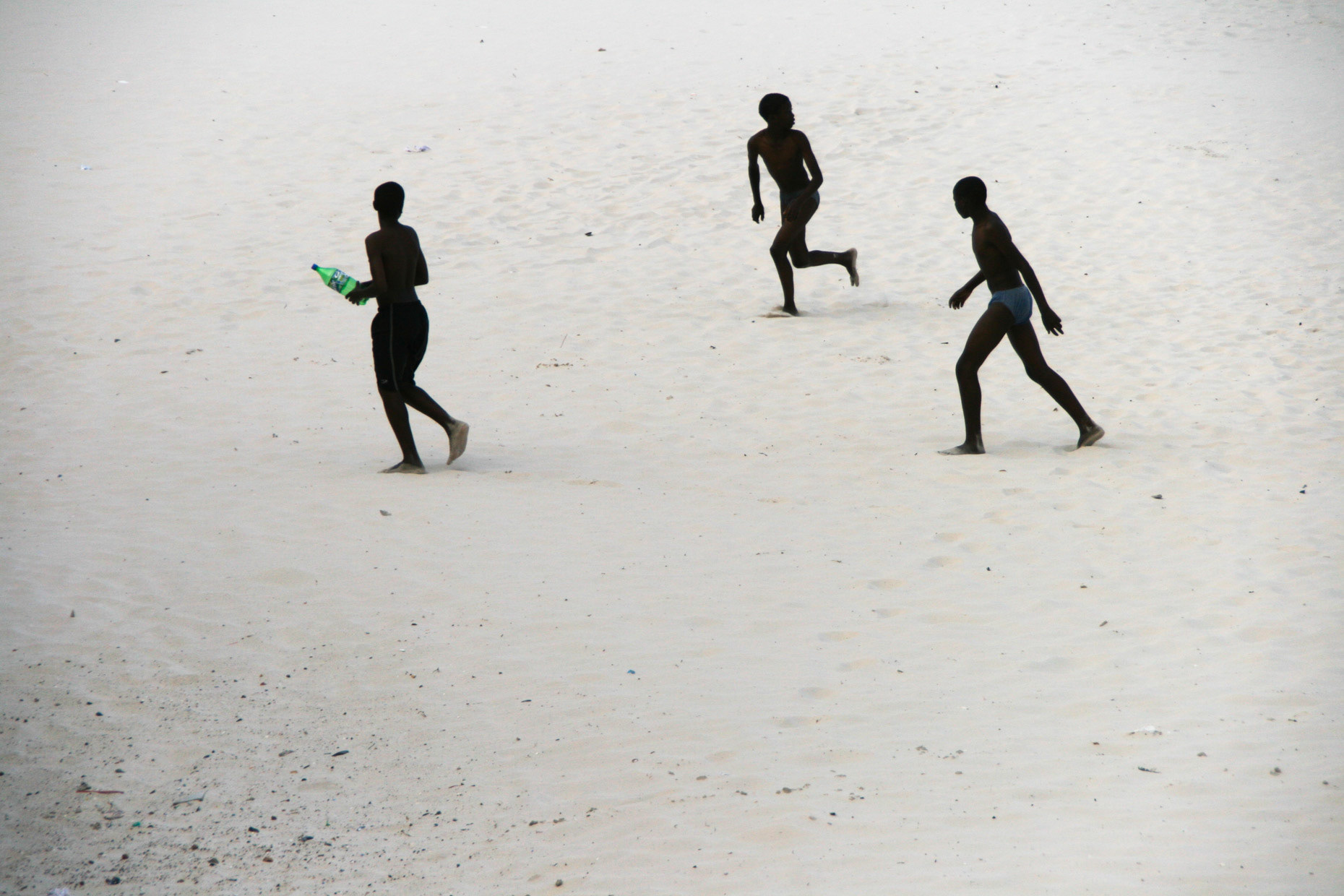 Three boys running across the beach in the suburb of Muizenberg in December 2008 in Cape Town, South Africa.