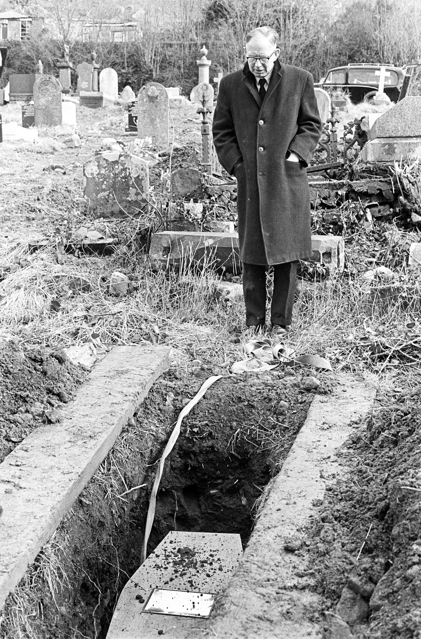 A pauper’s burial at Cefn cemetery - The deceased had no friends or relatives and the funeral was paid for by the council. Only the undertaker and a vicar were present. Griffiths the undertaker stands over his grave.