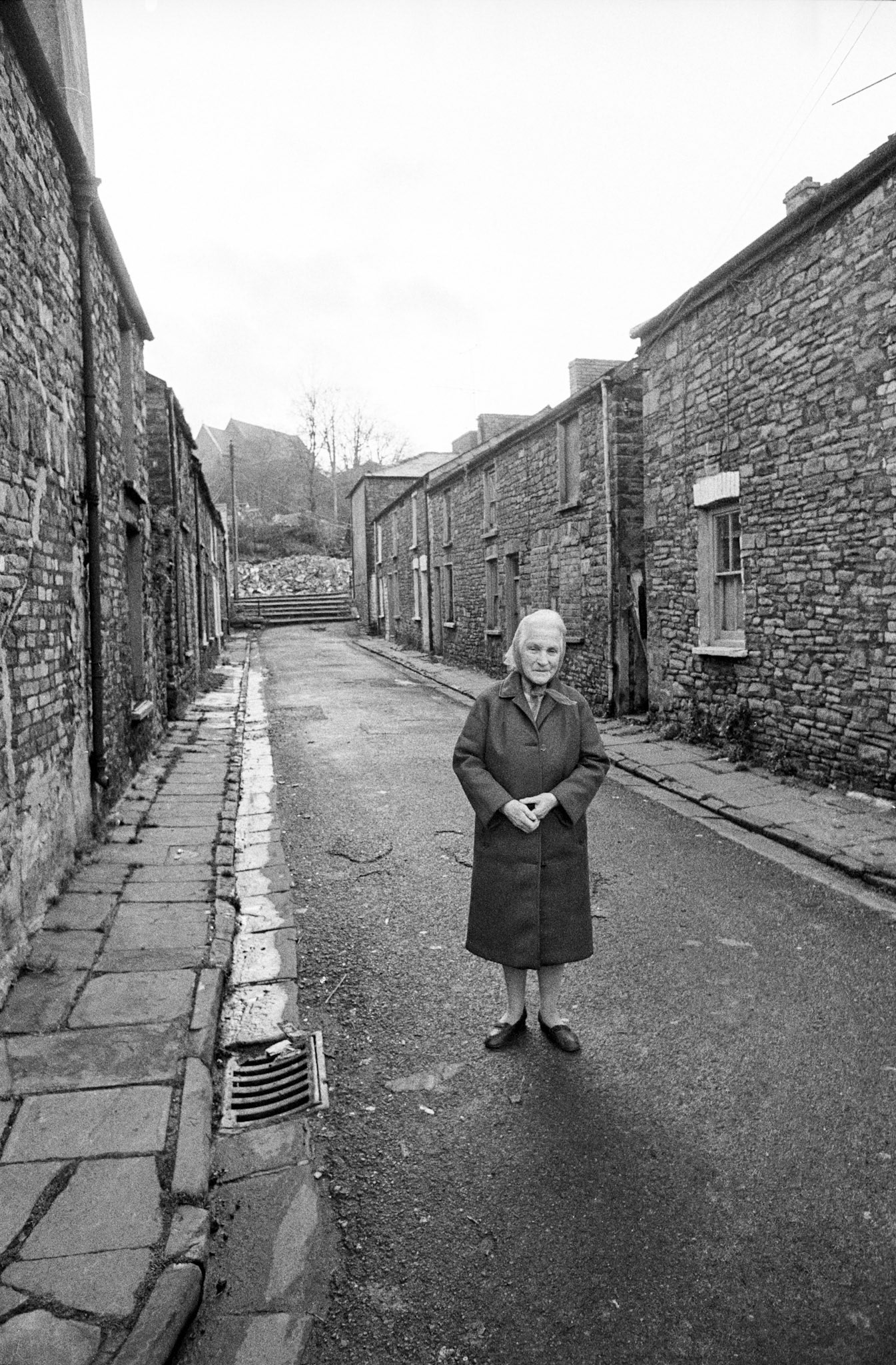 Woman in the street Georgetown - She appeared fragile and threatened by the stark stone of the street.
