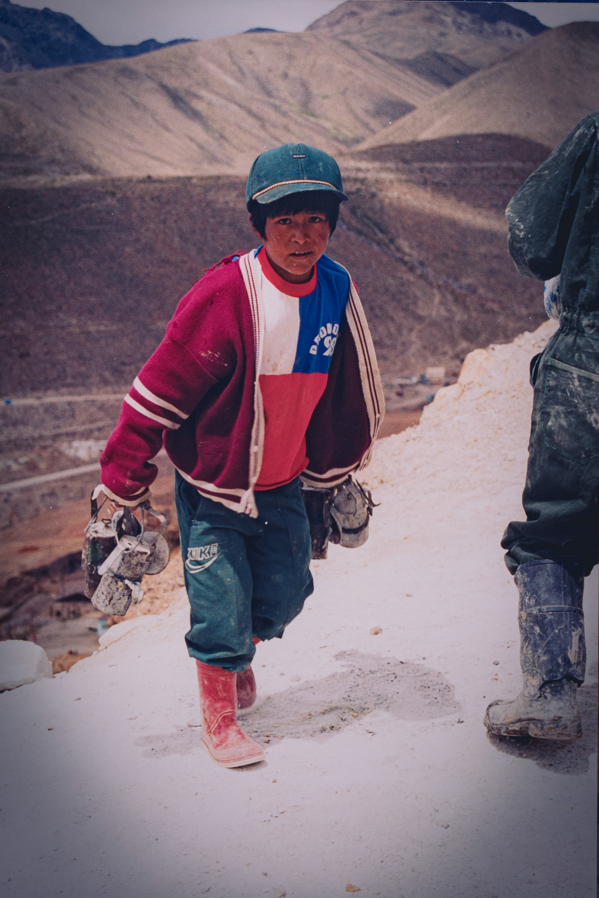 Niño llevando lámparas para los mineros que se internarán luego a trabajar en las galerías, con picos, barretas y dinamita.