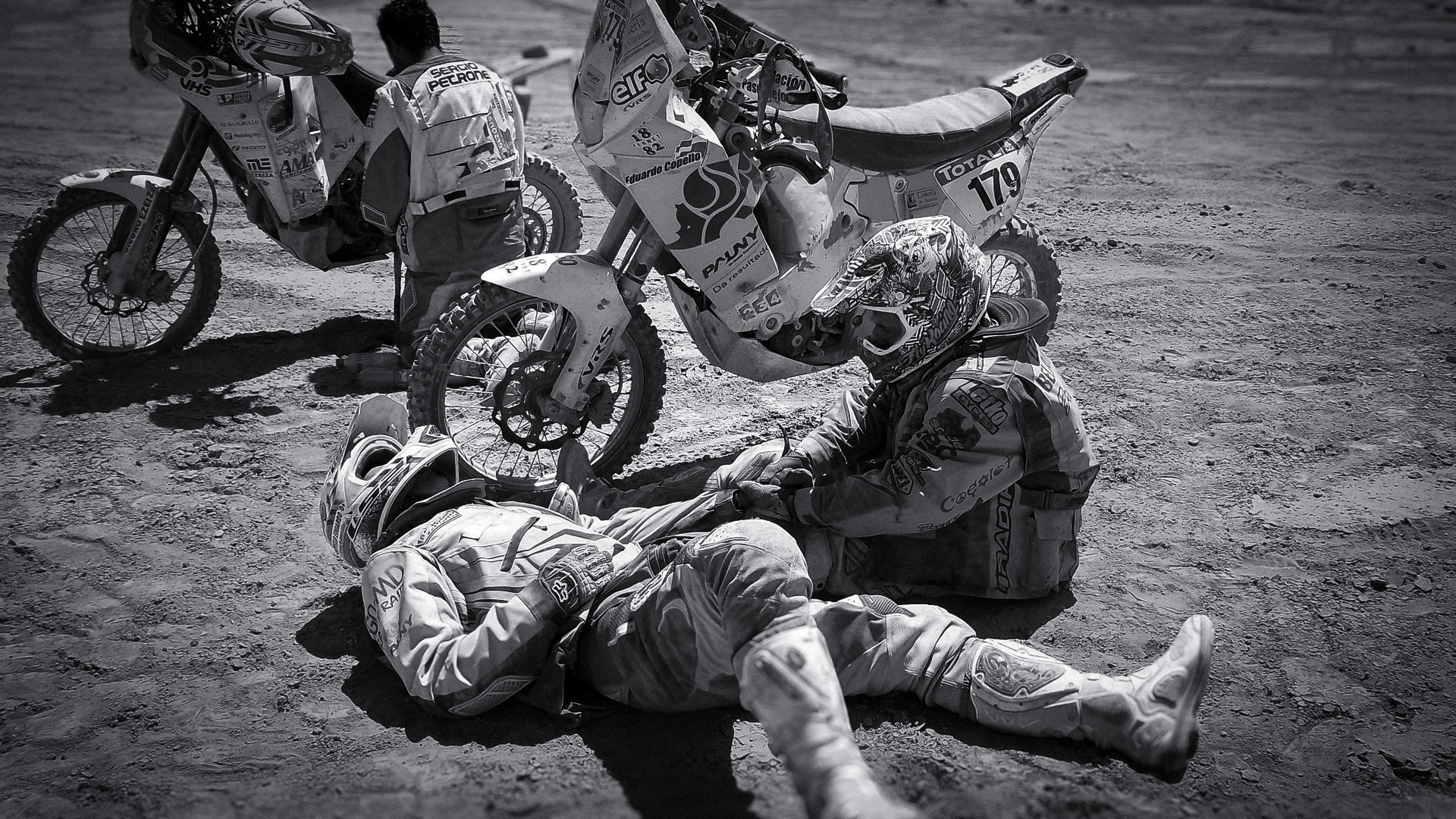 Dos pilotos asisten a otro accidentado en el Rally Dakar, en Chile.