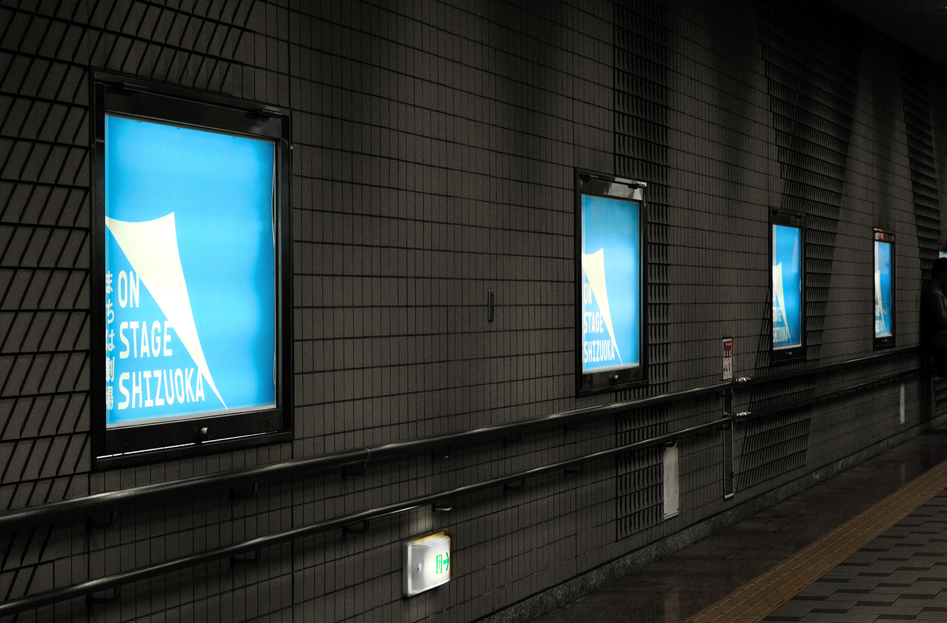 暗い駅構内に「ON STAGE SHIZUOKA」の広告ポスターが4枚掲載されている