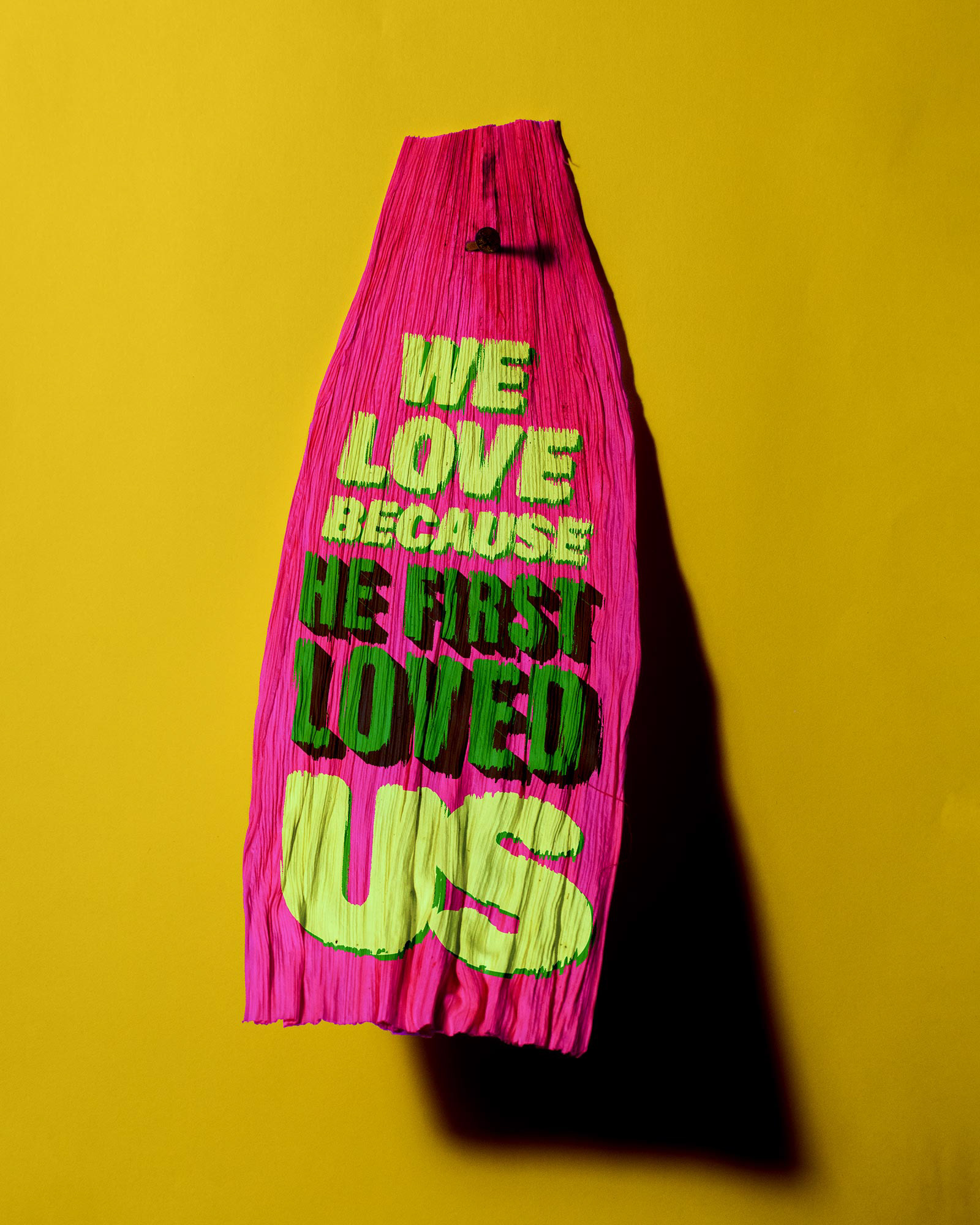 Tamale corn husk that says "We love because He first loved us", a reference to 1 John 4:19
