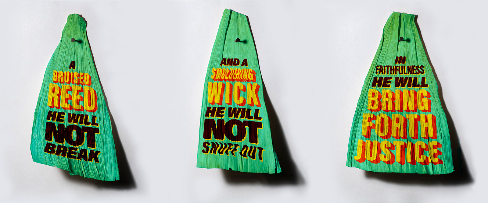 Three tamale corns husks that quote Isaiah 42:3, which reads "A bruised reed He will not break and a smoldering wick He will not snuff out. In faithfulness He will bring forth justice."