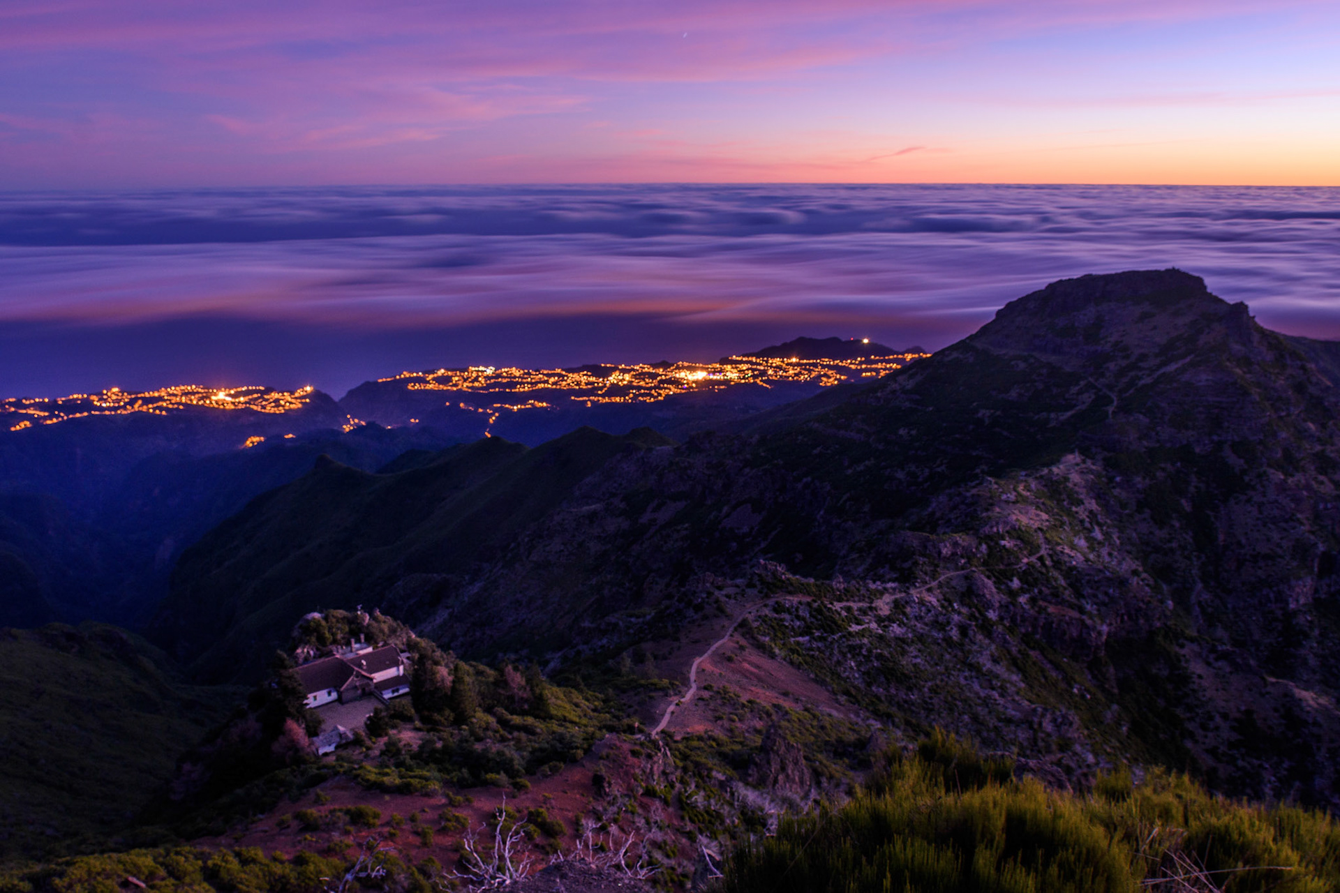 One day in December I was lucky to be the first person to witness the sunrise in Madeira, from its highest peak  - Pico Ruivo, 1862 m. Reaching up before 7 am wasn’t necessarily hard, however, the wind and the low temperatures added a bit of challenge to the climb. This picture was taken shortly before sunrise, when the little village of Santana (down) was still asleep under a dense cover of clouds, waiting for a new day to start.