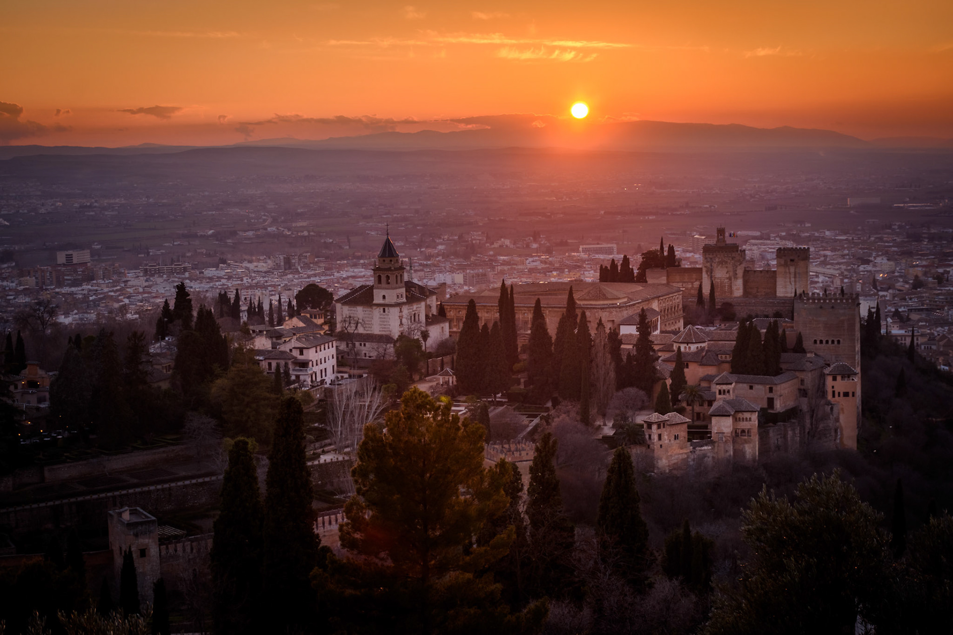 "Give him alms, woman,because there is nothing sadder in life than being blind in Granada".These lines by Francisco de Icaza are inscribed on the walls of  Alhambra - one of the most precious jewels of Arabic architecture in the world. The palace built in the 13th century was home to Nasrid dynasty - the last Arab rulers in Iberian peninsula. Later, it served as the royal court of Ferdinand and Isabella. It was here, where they extended their royal endorsement of the infamous expedition to India by Christopher Columbus. In this picture, the Alhambra and the city of Granada are fading in what Bill Clinton once called "the most beautiful sunset in the world".