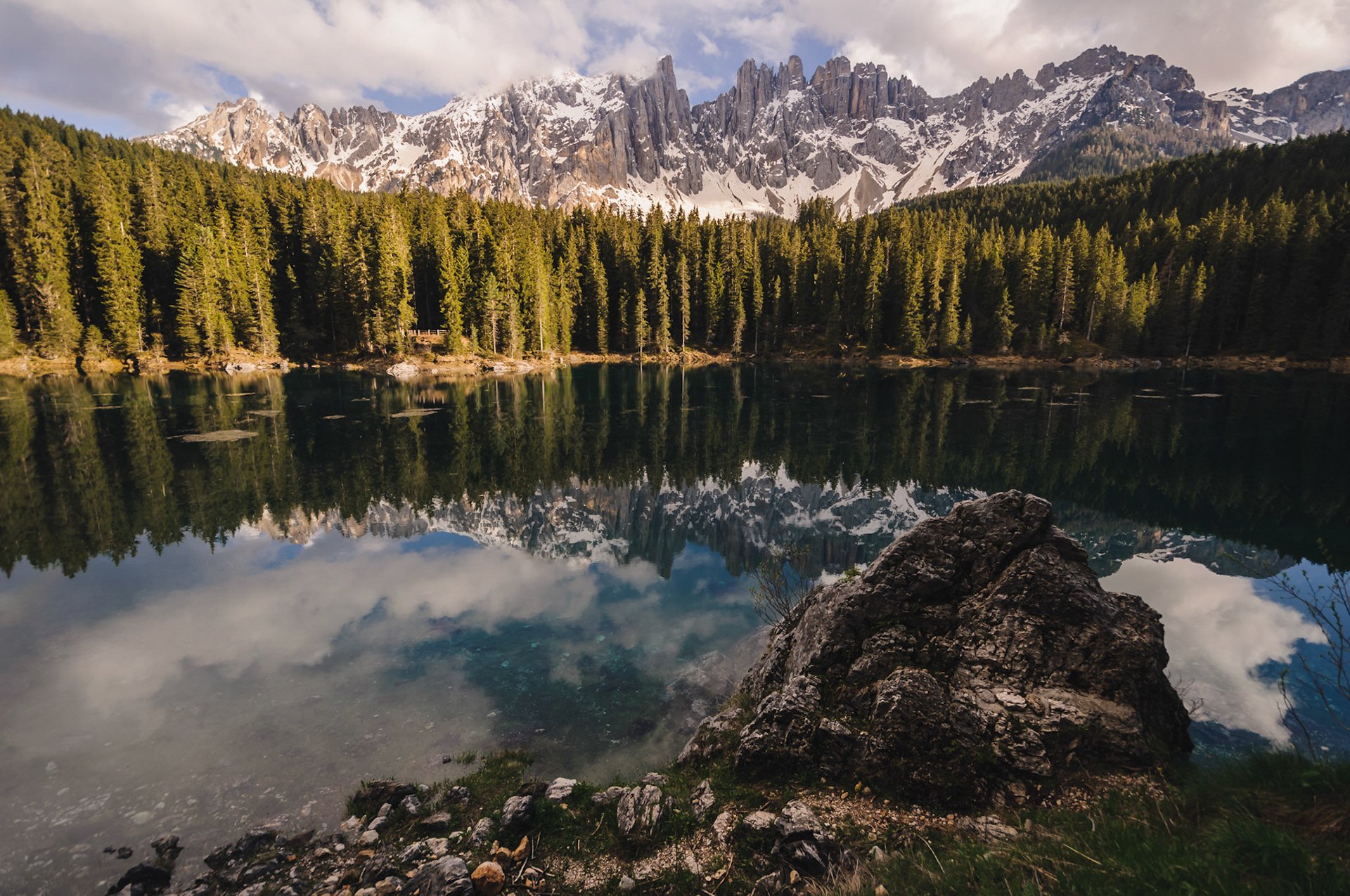 as the legend says in once upon the time a beautiful water nymph lived in the pristine waters of  lago di carezza. a wizard masaré, once heard her singing and fell in love, however, not even his magic was enough to win the nymph. with help from a witch,  an elaborate plan was born. masaré was supposed to stretch a rainbow from the lake and disguise as a jewellery salesman, just to be able to approach the nymph.sadly for the wizard, he forgot the salesman cloak and was recognized. the nymph jumped into the lake and was never seen since. angry masaré smashed the rainbow into pieces, which fell into waters of the lake. since then the ladin name of the lake is "lec de ergobando" (rainbow lake).