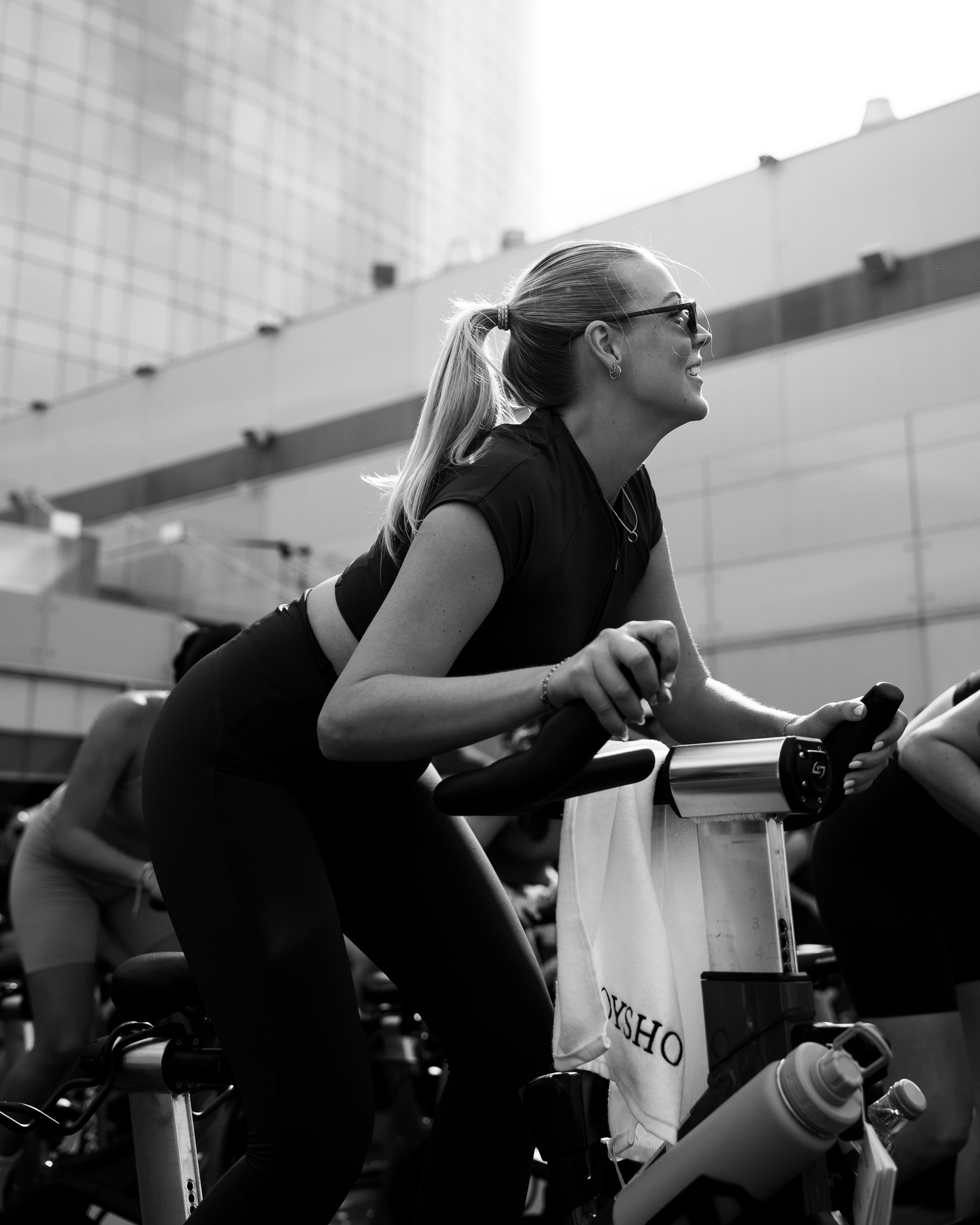 Rider on a spin bike at the Oysho x Lovecycle outdoor class, black and white