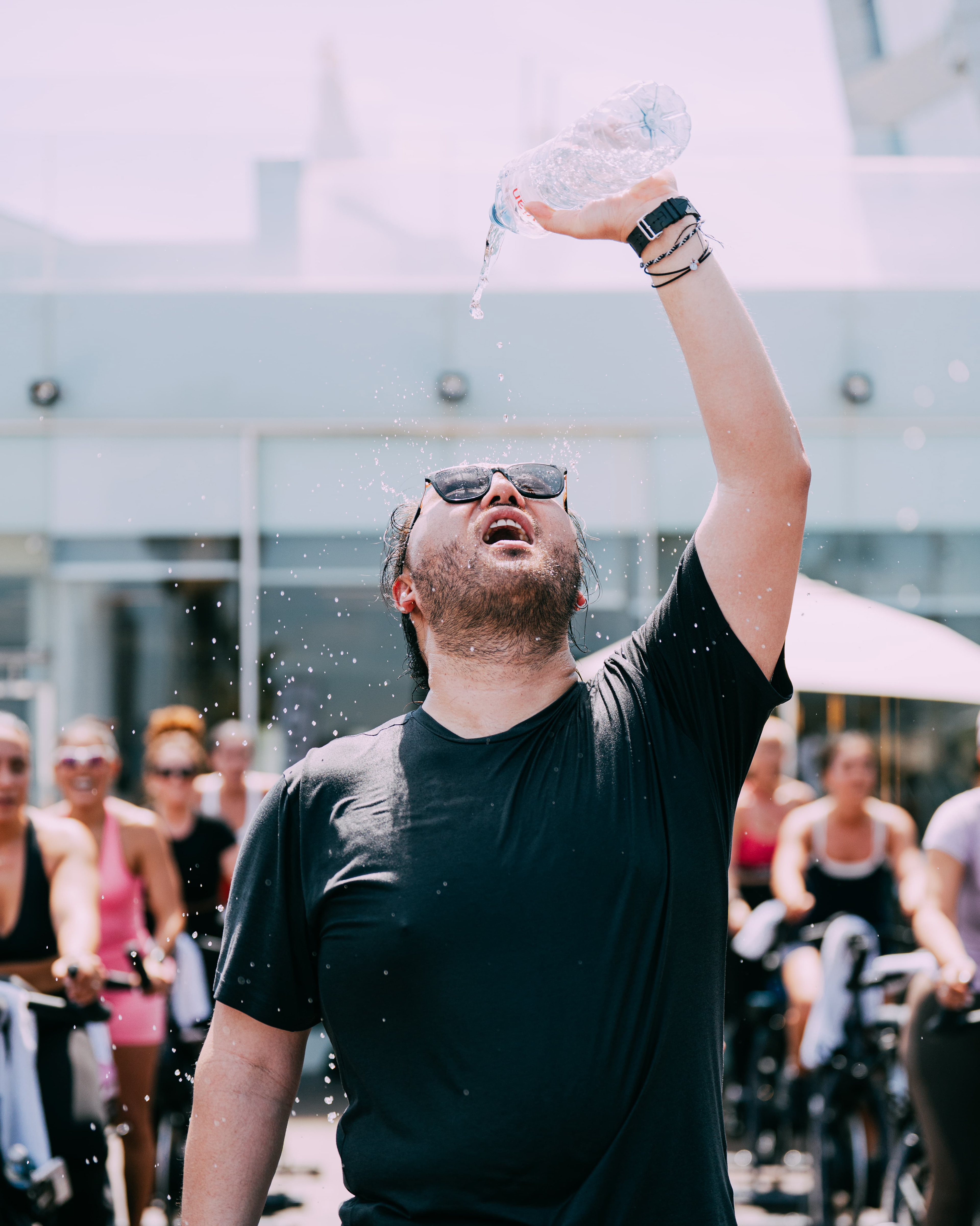 Rider pouring water over his face during the outdoor class