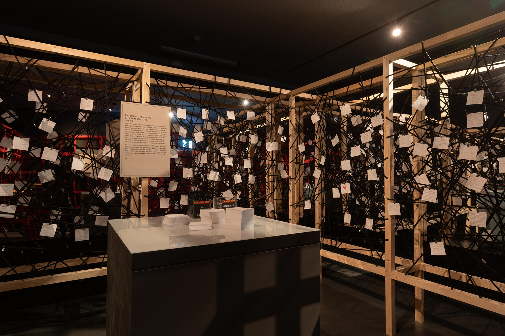 The interactive room is about 5x5 m big. In the framed wooden rack there are spanned black ropes on which you can hang the paper notes.