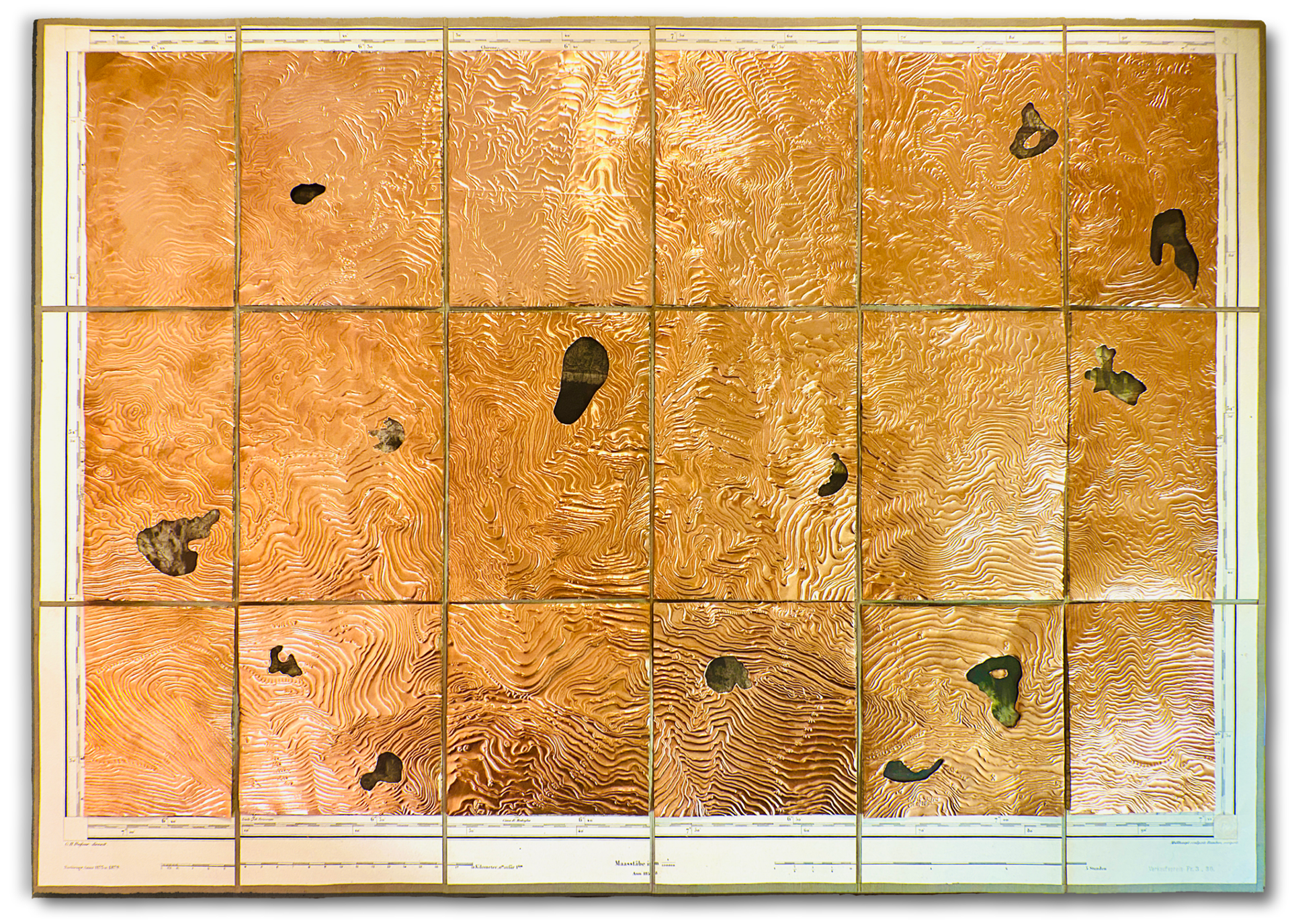 topography map with all map sectors covered in engraved copper sheets some of which have irregular cut out pieces revealing parts of the topographic map drawing and photographic negatives of landscapes