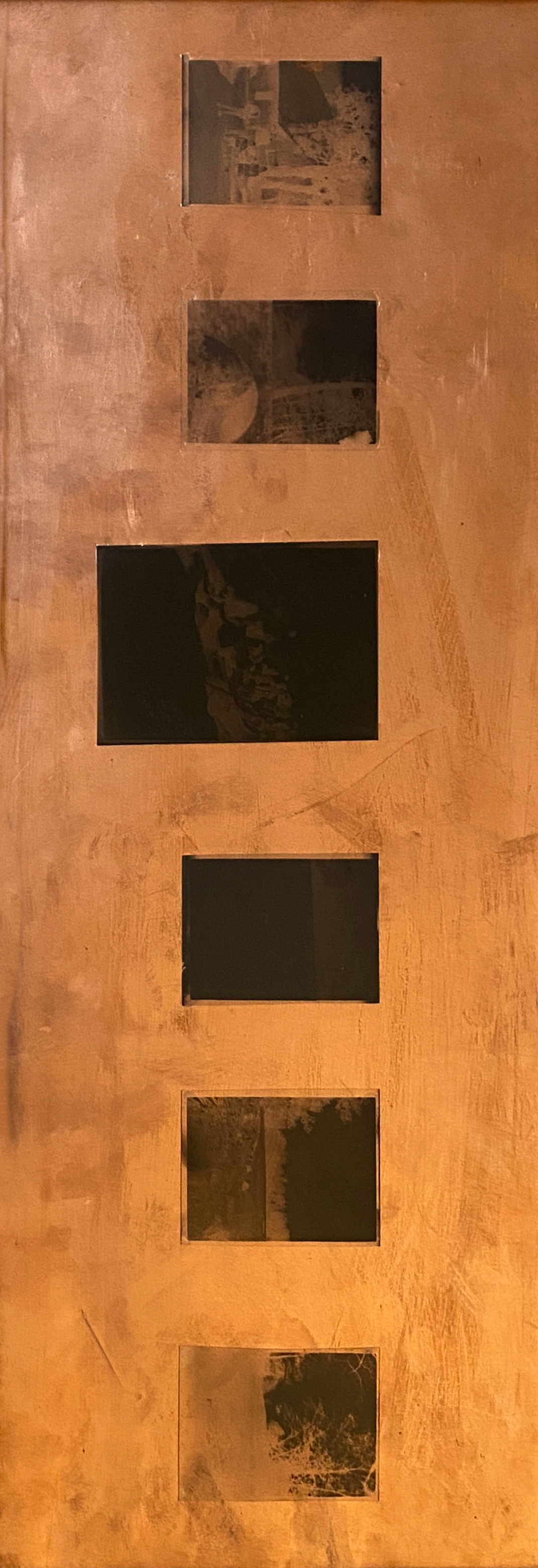 copper sheet metal overlayed with b&w negatives of various opacities depicting landscapes and people