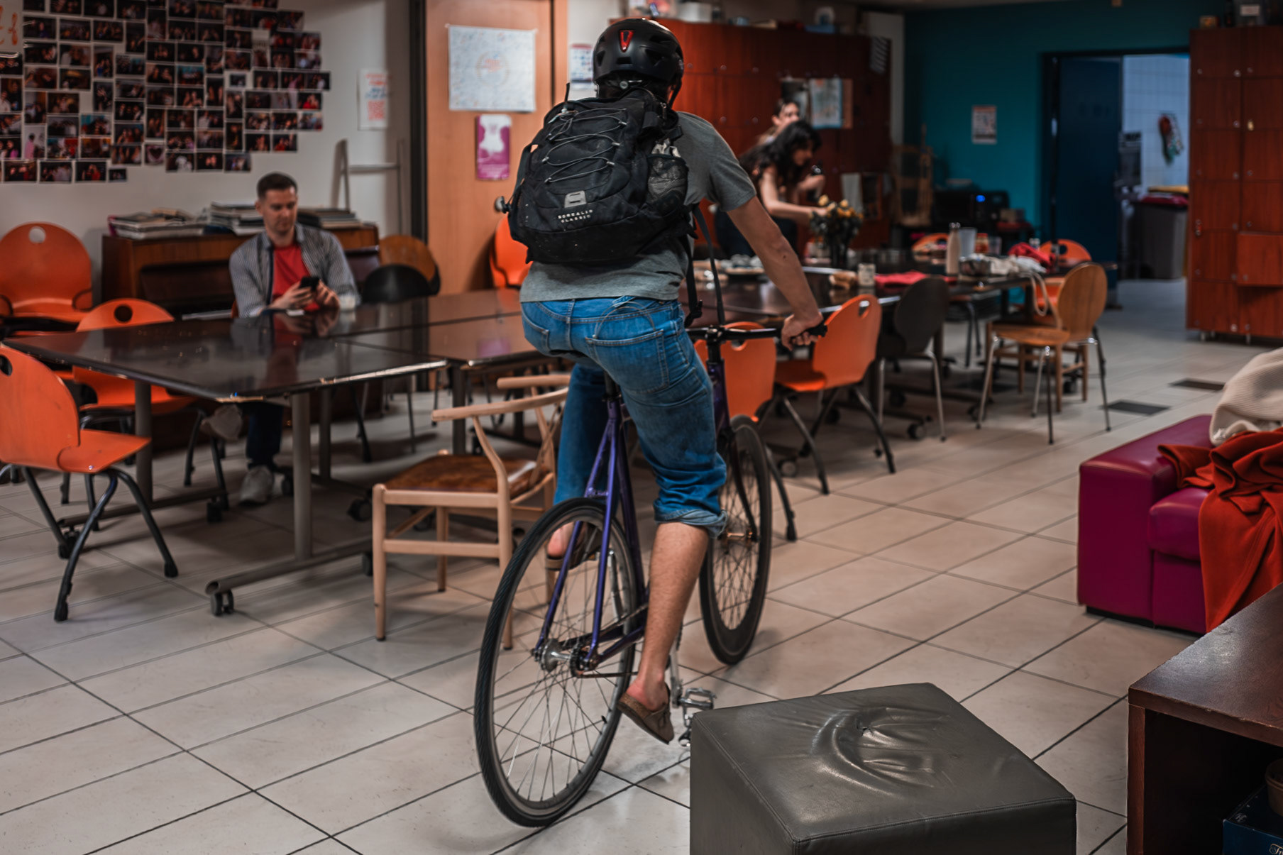In the main hall of AEPP, Basil shows his new bicycle to those around him. His habit of frequently doing so means the people in the background hardly react, continuing their routines. The image reflects the relaxed familiarity of shared student spaces. Picture taken the 2026-05-03©Aurora Ghigino