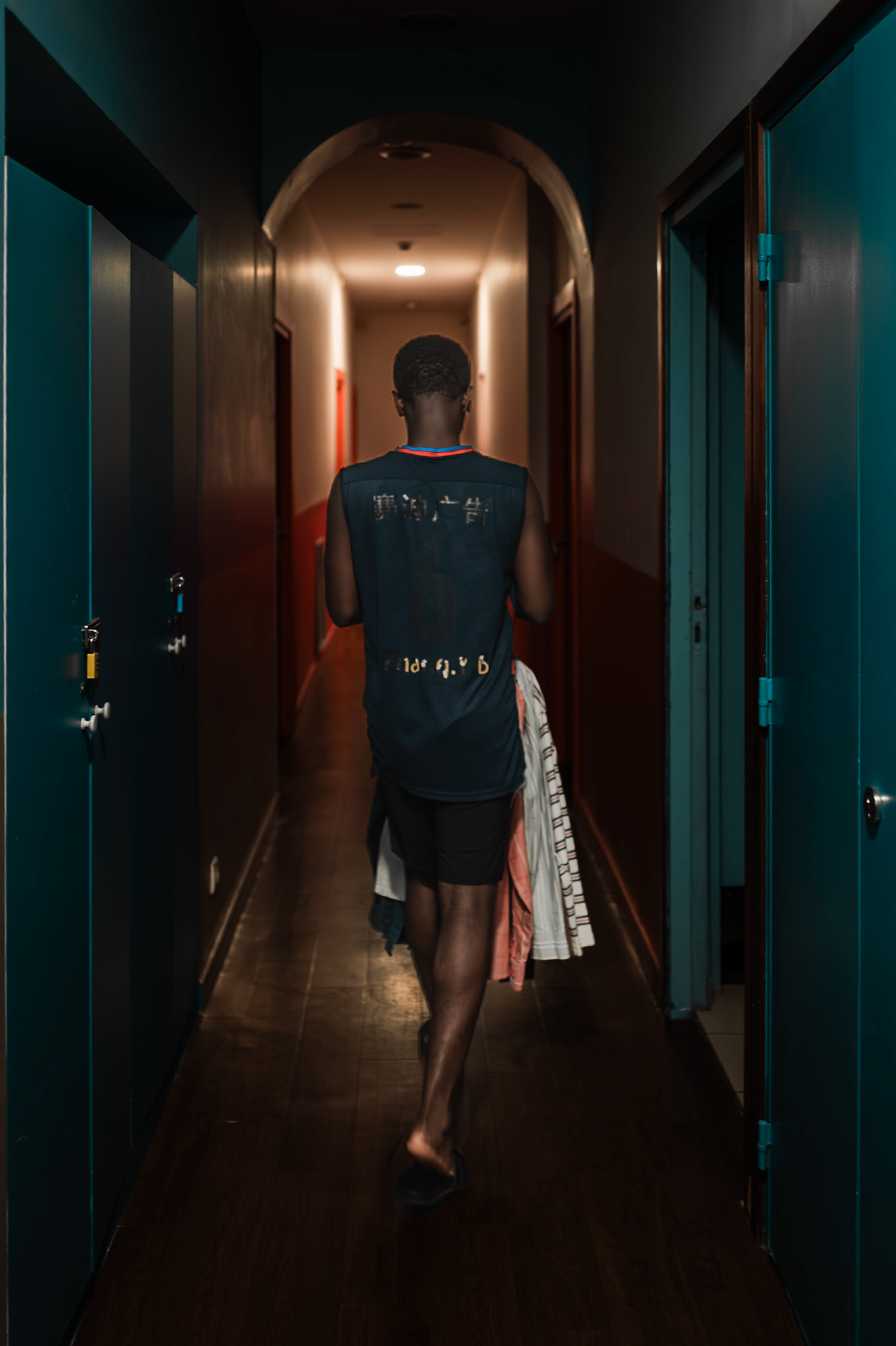 A student returns to his room carrying freshly cleaned laundry. The scene reflects a simple everyday activity, offering a glimpse into the daily rhythm of student life and residence living. ©Aurora Ghigino