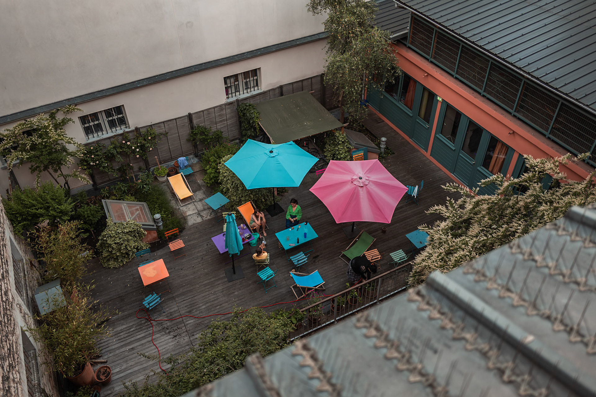 Viewed from a third-floor room, a group of girls can be seen on the AEPP terrace. Some areengaged in conversation, while one of them is taking care of the garden. The image reflects a calm, everyday moment of student life, combining social connection with a sense of responsibility for the shared environment.Picture taken the 2026-05-26©Aurora Ghigino