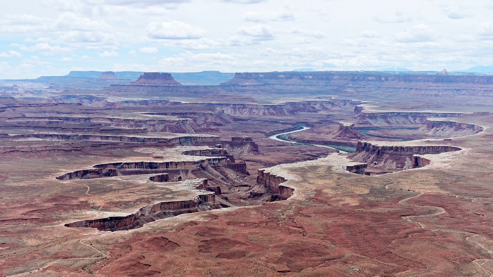 View over to the Maze from the Green River Overlook, Island in the Sky.  In the distance are Elaterite and Ekker Buttes. To the right of the river is the Turks Head and in the foreground the White Rim Trail. On the horizon to the right are Cleopatra's Chair and the Henry Mountains