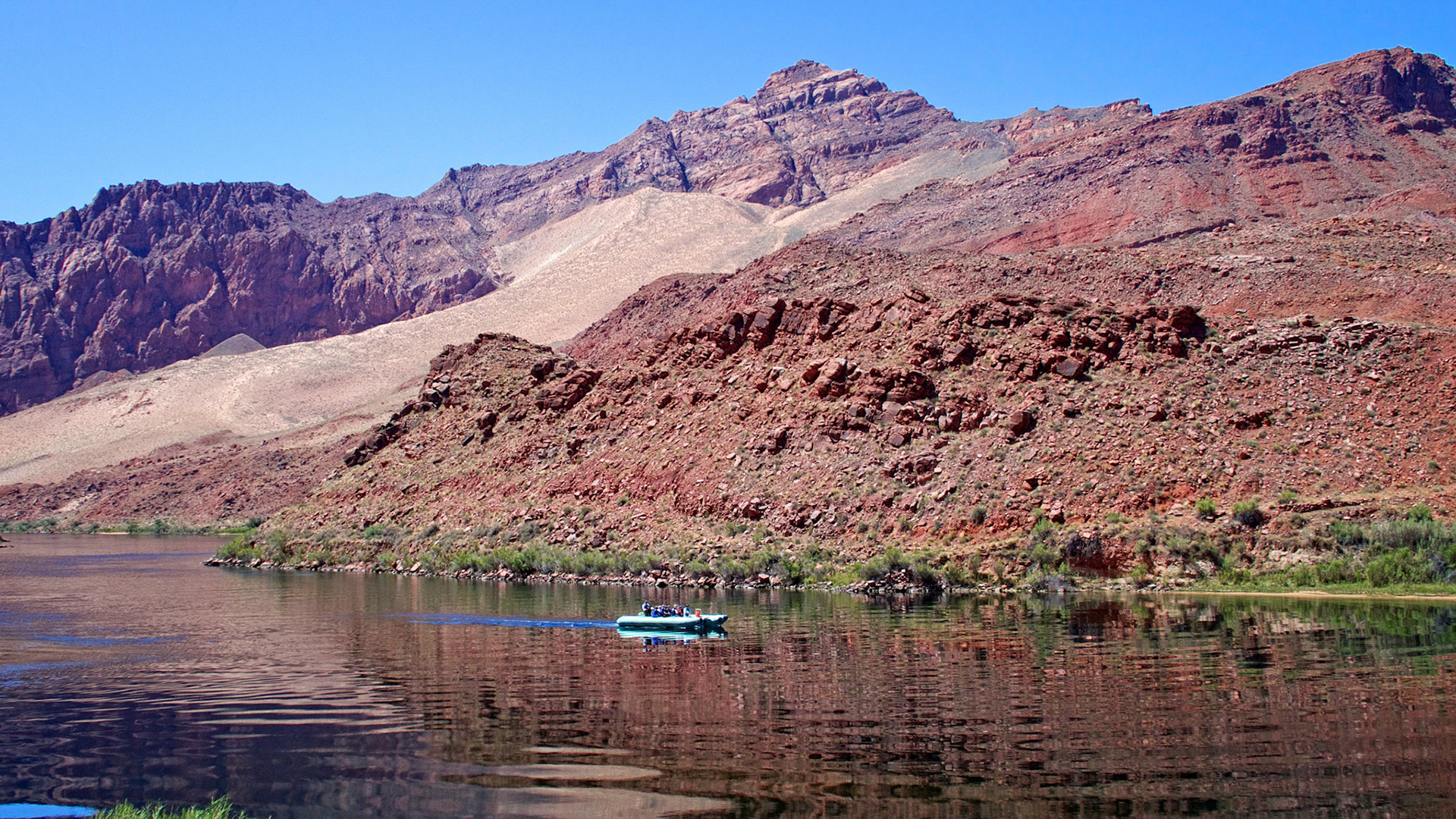 A small inflatable heads downstream on the Colorado River above Lees Ferry, Arizona.