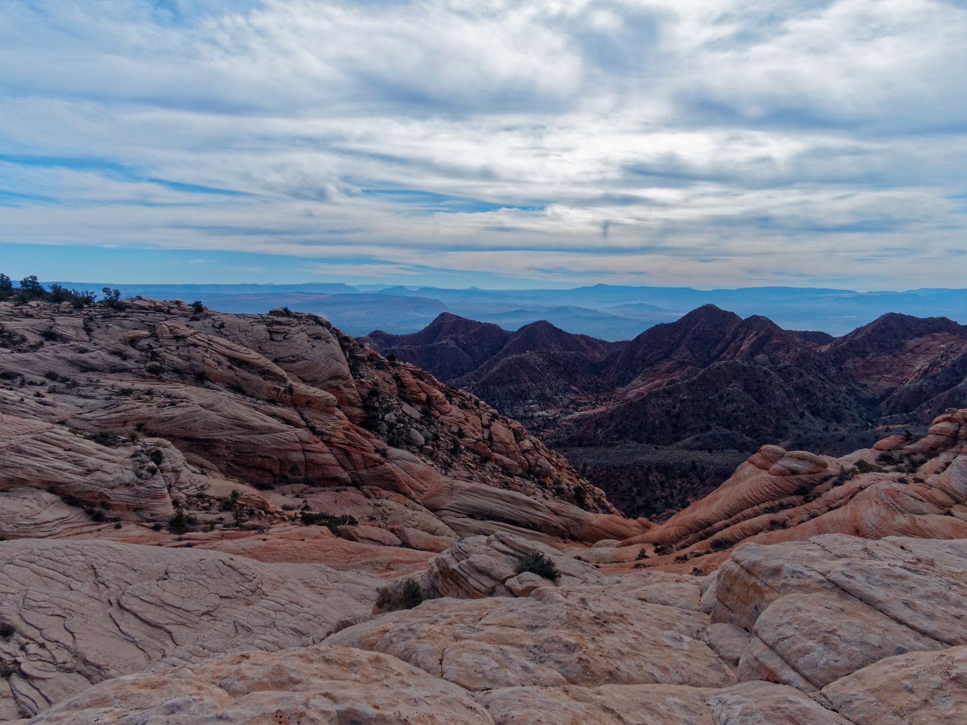 After crossing a sand dune the flat drops away to an area of slick rock. This is the view looking south over Washington and St. George, hidden in the valley, to the Arizona Strip.