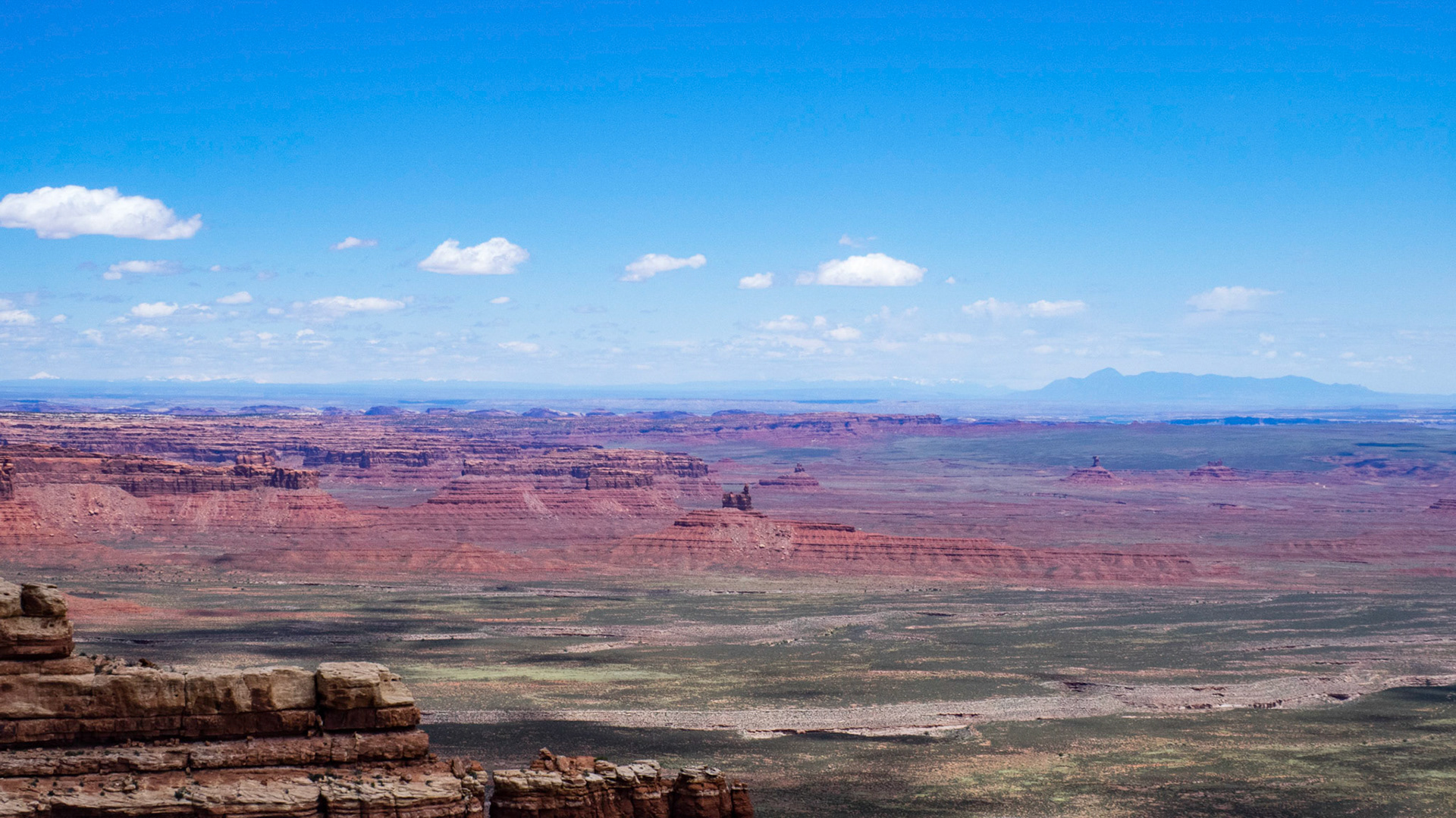 Another view from the Moki Dugway. In the right middle distance can be seen the rock formations of the Valley of the Gods with Comb Ridge to the left. The prominent mountain to the right is Pastora Peak in northern Arizona and to the left on the horizon can be seen the snow-capped mountains of northern New Mexico.