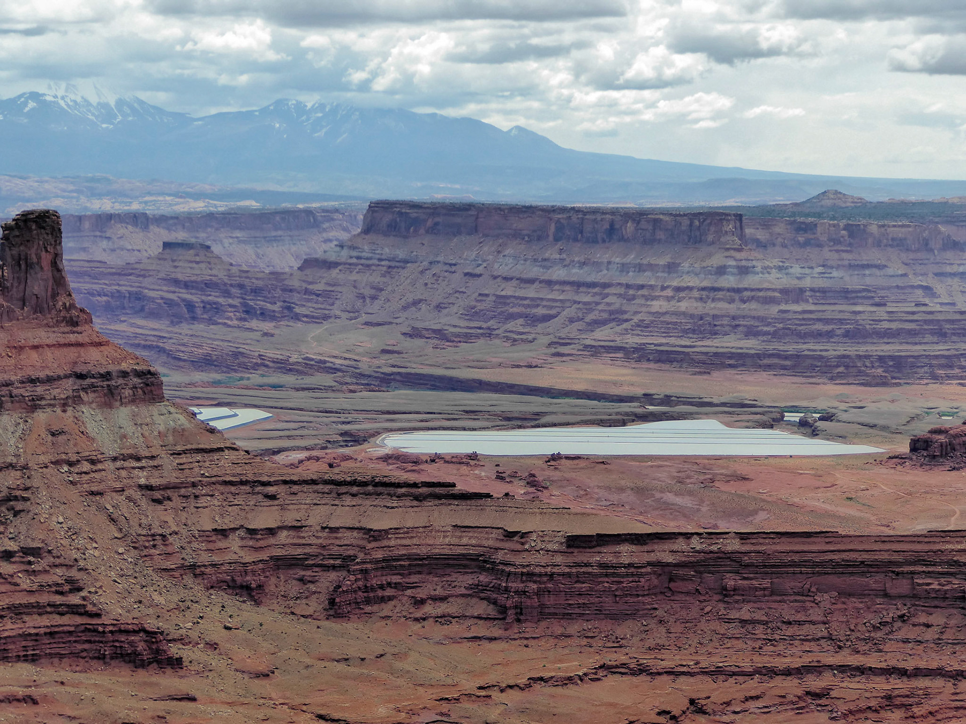 View east from Dead Horse Point over the potash ponds to the La Sal mountains, with Chimney Rock on the left.