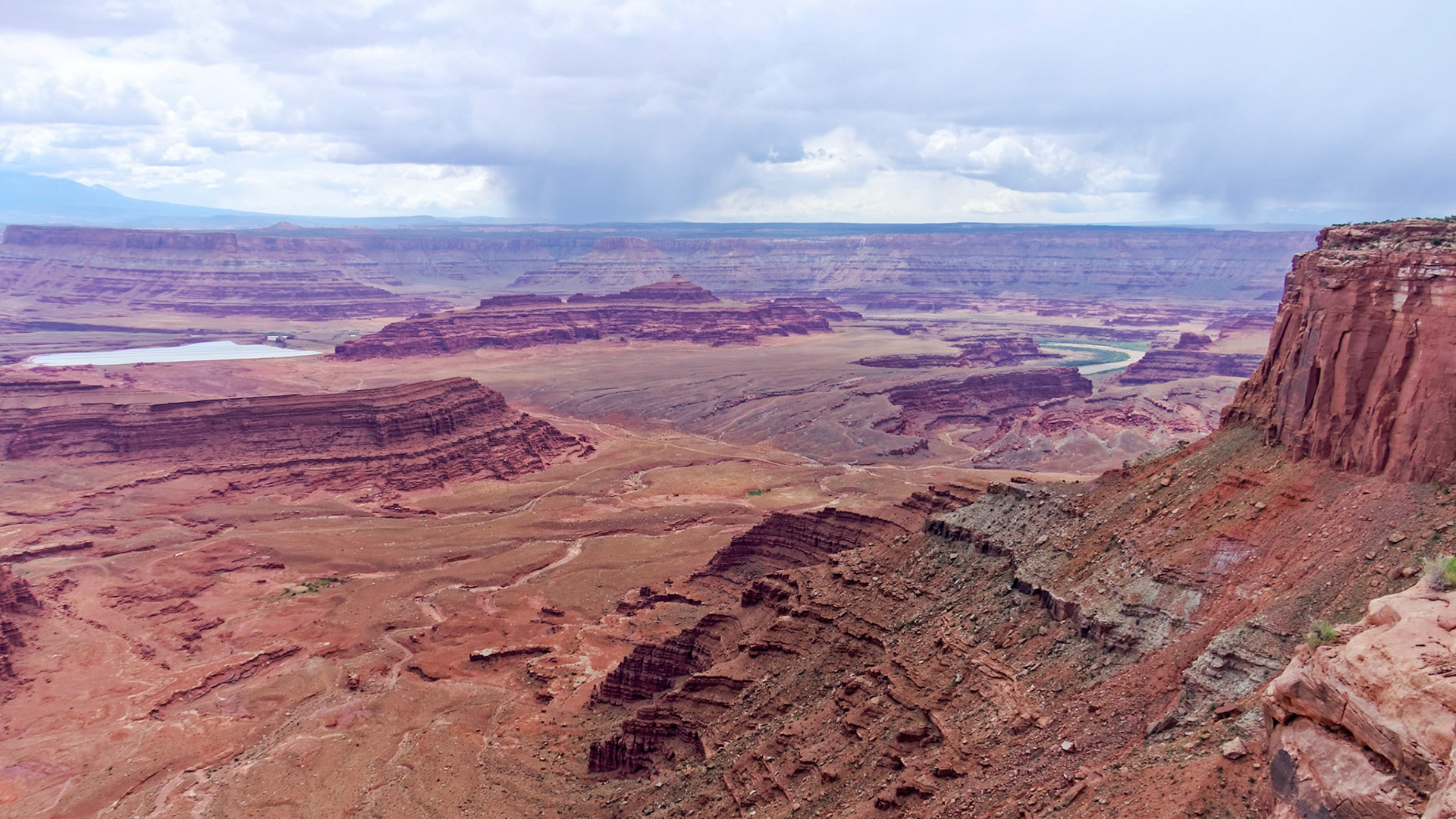 Stormy weather approaching Dead Horse Point over the potash ponds, Pyramid Butte and the Colorado River.