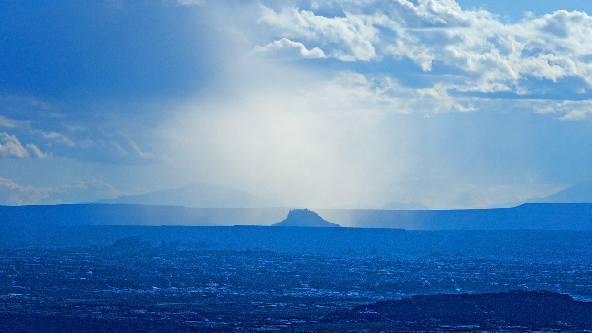 Shower over Bagpipe Butte. Looking over the Needles to the Maze from the Needles Overlook