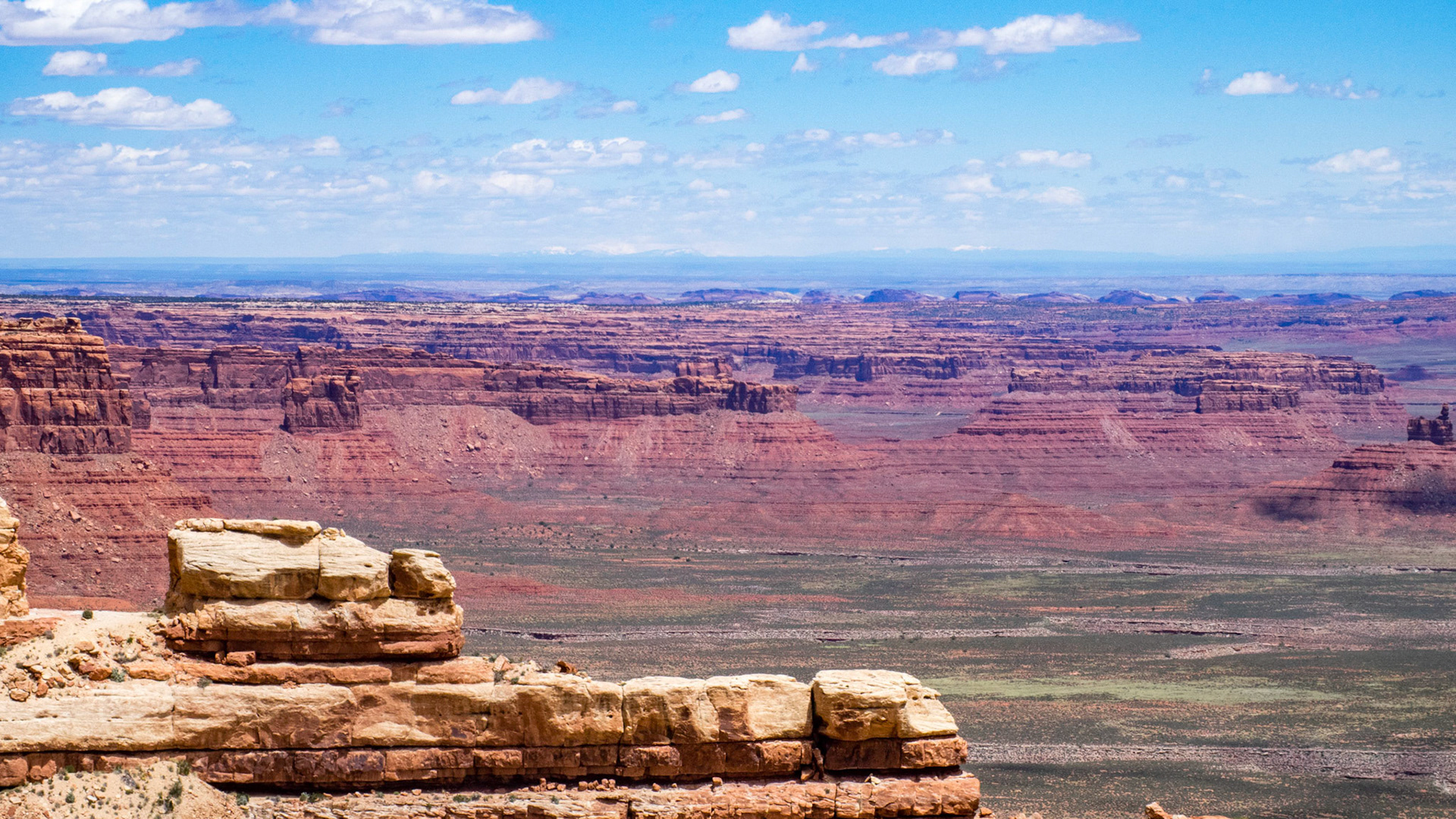 Utah State Route 261, part of the Utah section of the Trail of the Ancients, a National Scenic Byway, includes steep unpaved switchbacks as it descends the Moki Dugway. The Moki Dugway was constructed in 1958 by Texas Zinc, a mining company, to transport uranium ore from the "Happy Jack" mine in Fry Canyon to the processing mill in Mexican Hat. The State Road Commission added SR-261 to the state highway system in 1957. This picture shows the view from the Moki Dugway over to Comb Ridge in the middle distance.