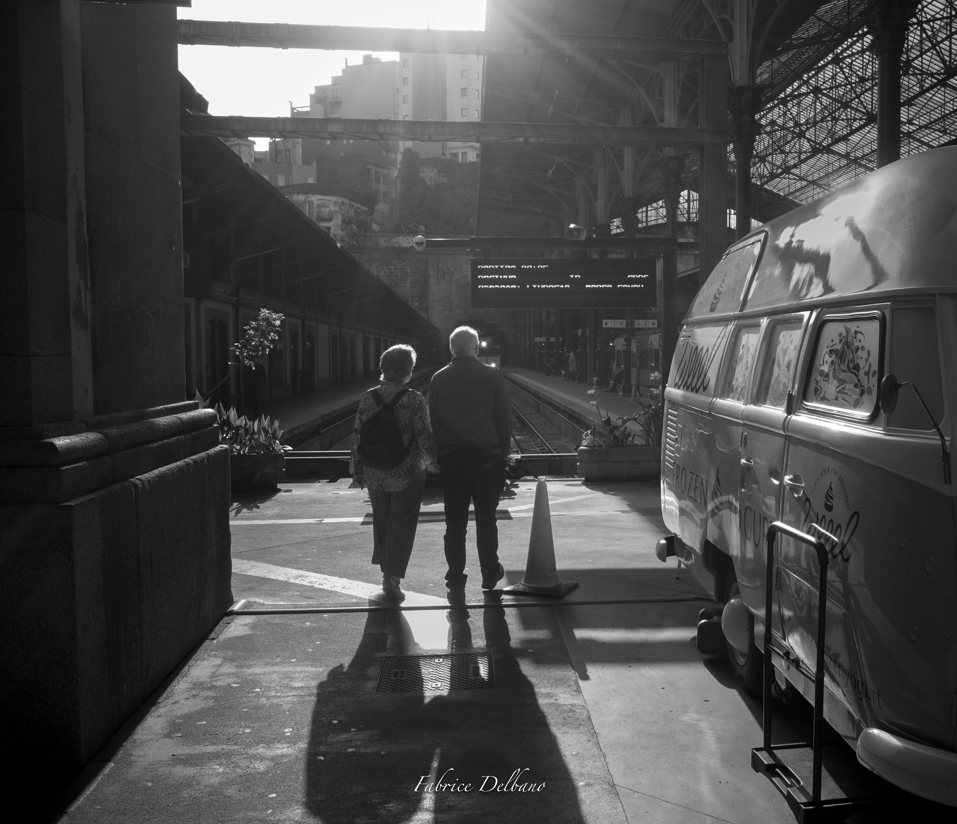 Noir-et-blanc, gare de Sao Bento à Porto, couple en contre-jour regardant un train arriver