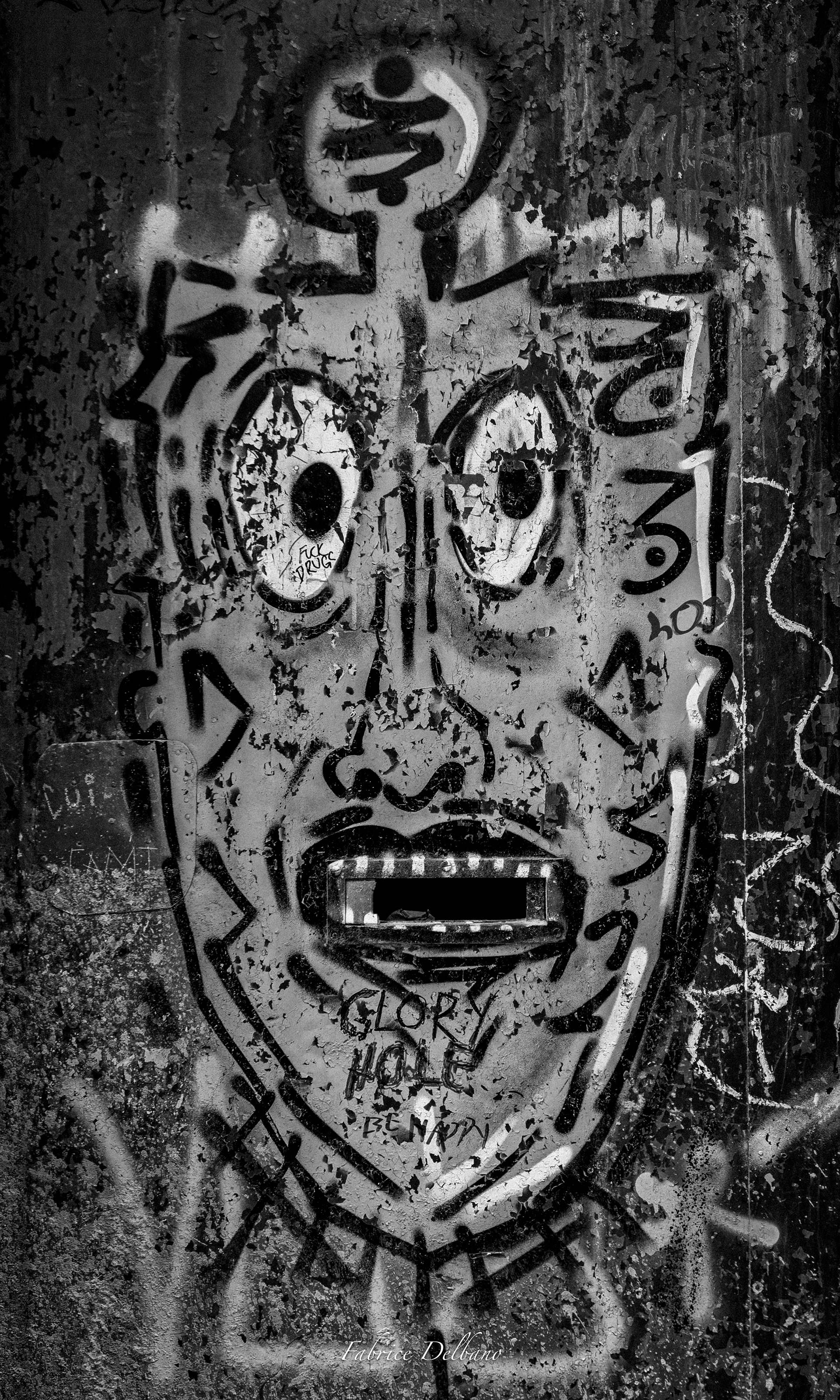 Noir-et-blanc, graffiti tête d'homme sur un mur de Port, légende Glory Hole