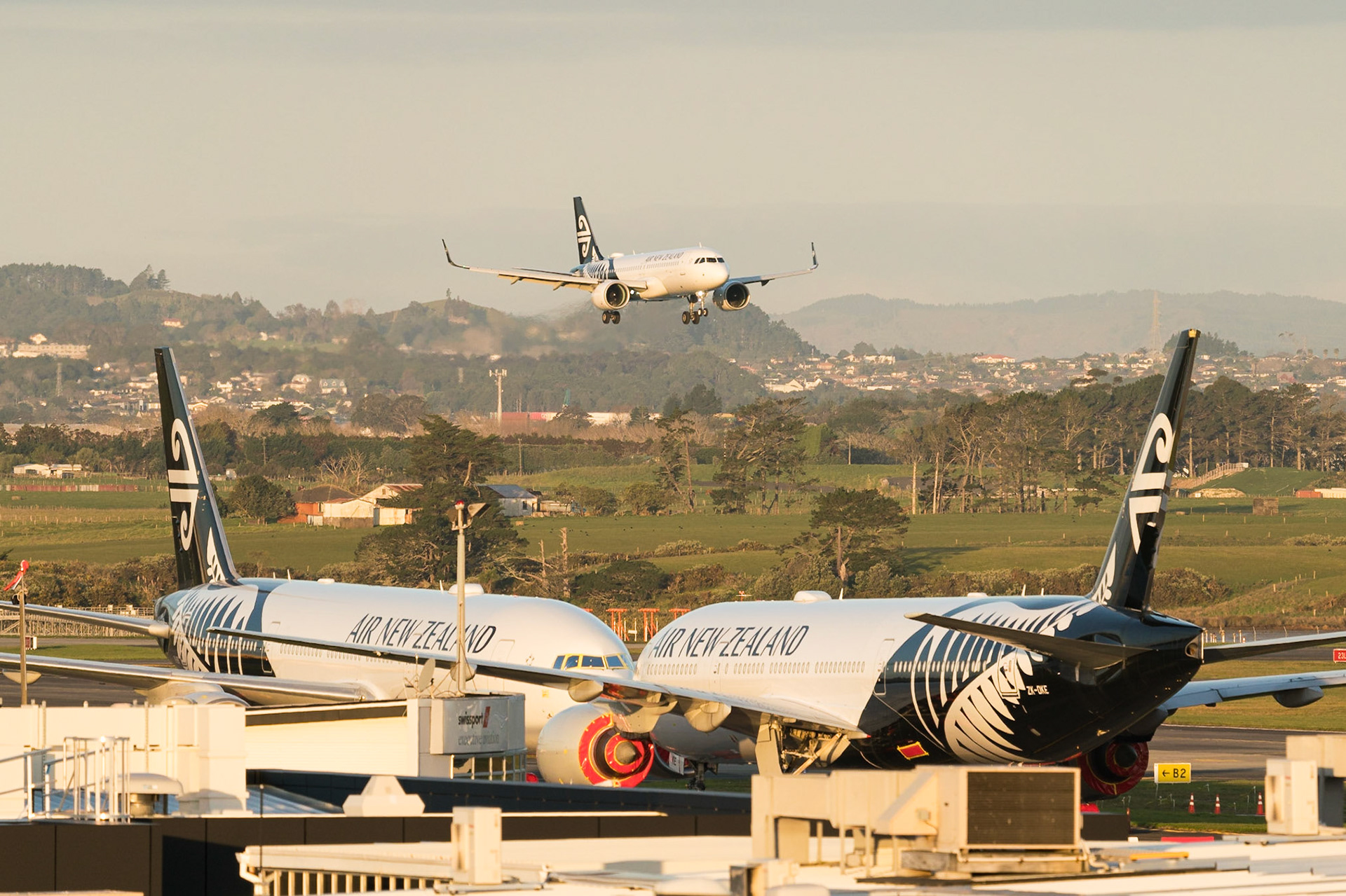 Air New Zealand Airbus A320NEO arriving over the top of two Boeing 777-200ERs, awaiting their fate.