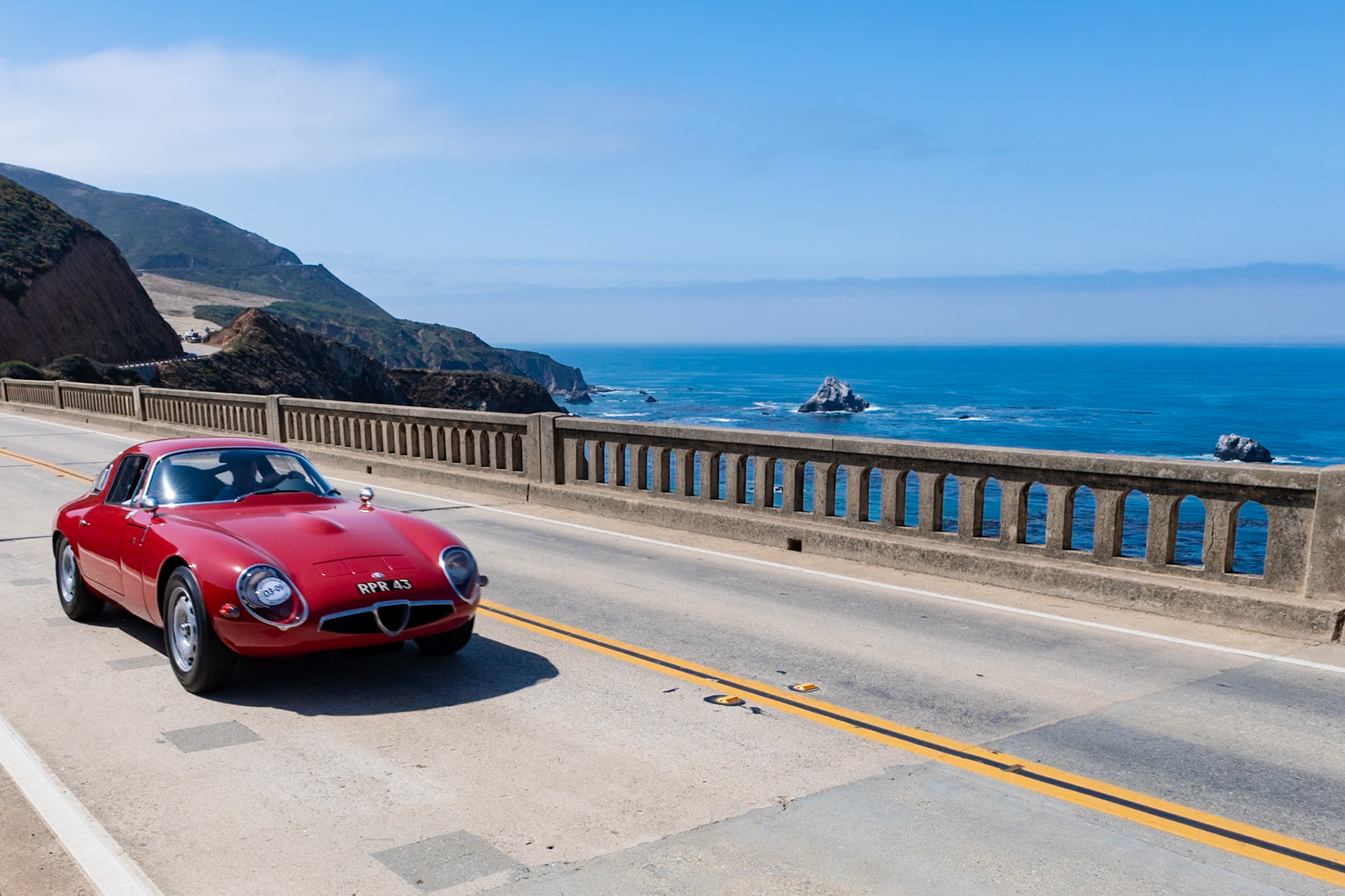 The Alfa Romeo Giulia Tubolare Zagato (TZ), which replaced the Giulietta Sprint Zagato (SZ), was manufactured by Alfa Romeo from 1963 to 1967. The TZ1 and later TZ2 were developed with Autodelta, a company led by Ex-Ferrari engineer Carlo Chiti. The TZs featured Alfa’s 1,570 cc twin-cam engine fitted in a tubular space-frame chassis with aluminum bodywork, disc brakes and independent suspension. Only 112 examples of this special Alfa Giulia were built. This ultra-lightweight TZ was delivered to Switzerland for racer Walter Pauli, who competed with it primarily in hill climbs. The car was never seriously damaged, and its original bodywork, glass, and mechanicals have all survived. In 1987 the car was acquired by another Swiss collector, Albert Obrist, who had it restored in the workshop of Angelo Chiapparini. He sold the car in 1995 to F1’s Bernie Ecclestone, who later passed it to racer John Coombs.