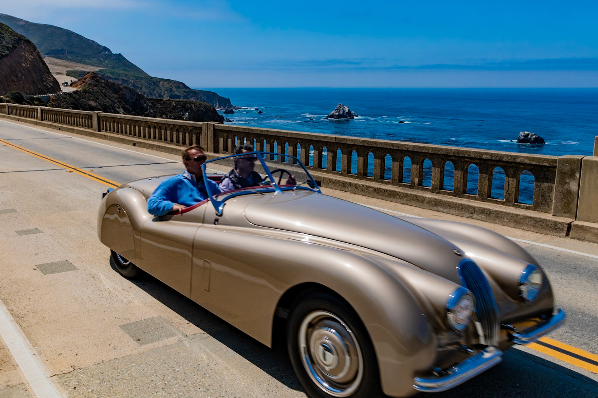 The Jaguar XK120 two-seater roadster was launched at the 1948 London Motor Show where it caused a sensation. The following year, Clark Gable, already the owner of a Jaguar MK IV Saloon, purchased the first left-hand drive XK120 roadster in America, and he liked it so much that in the ensuing three years he purchased several more. Gable bought this particular XK120 roadster (chassis 67623) in 1952 and decided to revise it to his own design. He sent it to George and Sam Barris, the original Hollywood “Kings of Kustoms,” for a few tasteful modifications, blending the front fenders and headlights and smoothing the boot line by removing the recessed license plate holder. The car was then finished in Barris Gold Bronze Lacquer and a special Carson-type padded top was fitted in order to give Gable more headroom. The current owners found it in 2009 and had it restored in 2014.