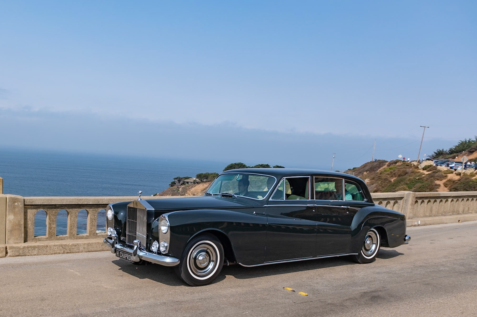The new top-of-the-range Rolls-Royce Phantom V, introduced in autumn of 1959, replaced both the Phantom IV and the Silver Wraith. It had a new 6,230 cc all-alloy V8 engine that was also used in Silver Cloud II and Bentley S2 saloons, and it was built on a modified and strengthened Rolls-Royce Silver Cloud II 145-inch wheelbase chassis. With suitably luxurious coachwork, the finished cars measured well over 20 feet in length. Despite its size, the Phantom V was still quite capable of exceeding 100 mph. Many of the first orders came from the royal families of Europe and other dignitaries, but the bulk of inquiries came from industry or private individuals. Over the course of its 9-year production run, 516 Phantom Vs were sold, and most were built in England. This striking Limousine is an exception, boasting what is possibly Henri Chapron’s largest-ever body, designed for Mrs. K. Millbank of Paris. It first appeared at the 1961 Paris Auto Salon and has just been restored to its appearance there, with the deep green paintwork and pale green interior.