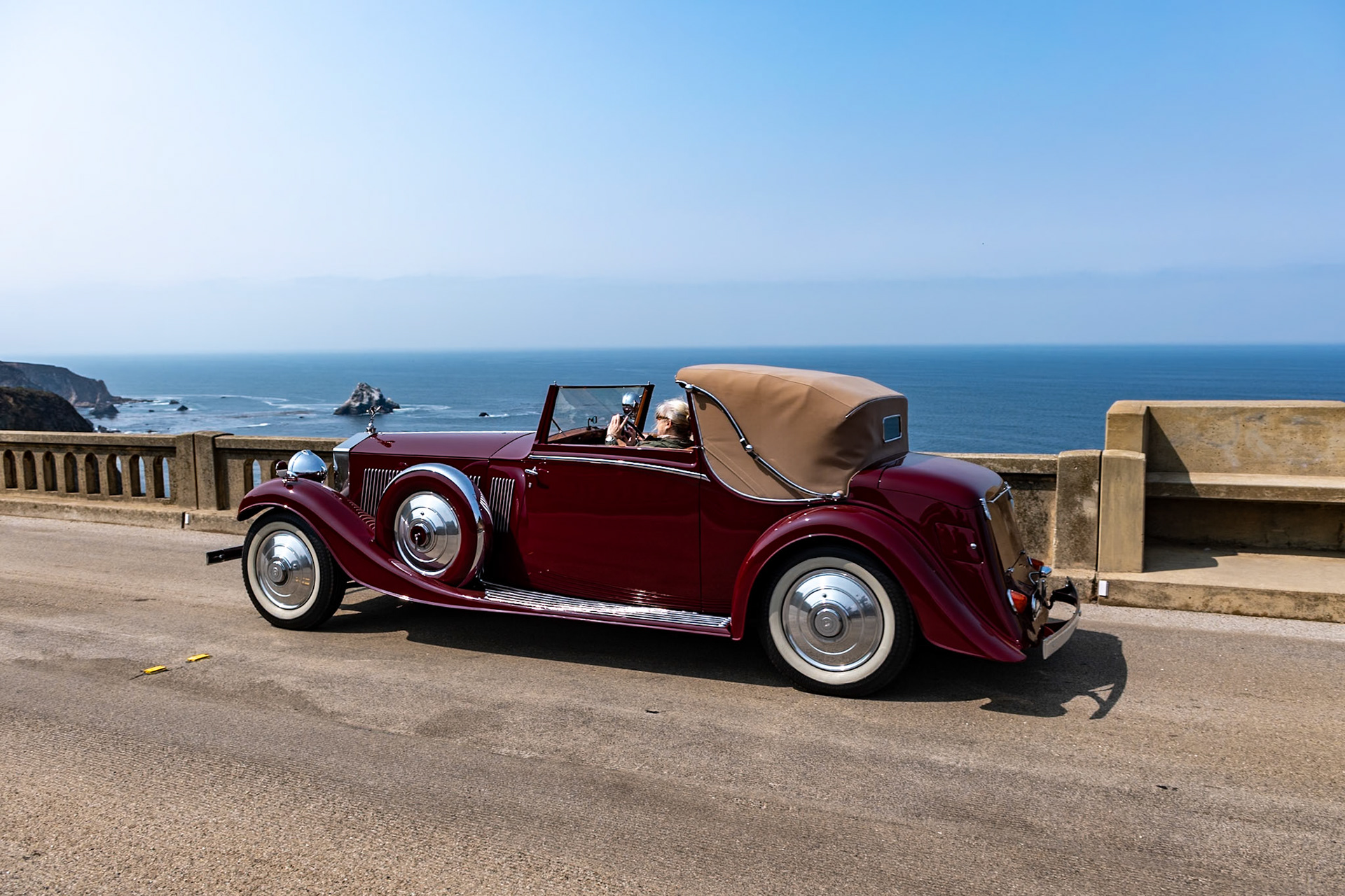 The much-improved Rolls-Royce Phantom II was introduced in September 1929, replacing the outdated New Phantom. Between 1929 and 1935, 1,672 Phantom IIs were built, including 280 on the stronger and shorter 144-inch Continental chassis, built to carry four people in comfort at high speeds. To balance the heavy chassis, lightweight coachwork was often fitted on it; the majority of Phantom IIs had 4-door closed coachwork, but a small number were fitted with more stylish designs, such as this Drophead Sedanca Coupé built by H. J. Mulliner in London. Described by Mulliner as a sportsman’s coupé, this is one of five similar PII Continentals built to be as lightweight as possible; they even included a special Exonite cellulose–covered aluminum steering wheel designed for aircraft. This Phantom II (chassis 55RY) was originally purchased by John “Jack” Upson, the owner of the famous Monseigneur Restaurant in Piccadilly and the chairman of the Dolcis shoe empire. It was acquired by its current owner in 1987.