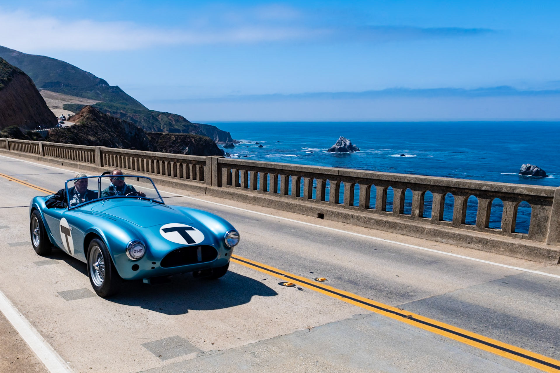 This car (chassis CSX 2005) is the fifth Cobra built; the AC factory listed its build date as July 17, 1962, and it was invoiced to Shelby American that September. It was featured in the 1964 film The Killers, a Universal Studios production based in part on a short story by Ernest Hemingway and starring Lee Marvin, Angie Dickinson, Ronald Reagan and John Cassavetes. In 1964 it was sent to the newly opened Carroll Shelby School of High Performance Driving at Riverside Raceway, where it was driven by many aspiring celebrity race drivers, including Steve McQueen and James Garner as well as a Miss Universe. Here the Roadster is presented in its school uniform of light blue metallic paint complete with its distinctive large letter T for Trainer. Its original body panels and hand-stamped and numbered fittings have all been restored to be exactly as the car was when running around Riverside Raceway.