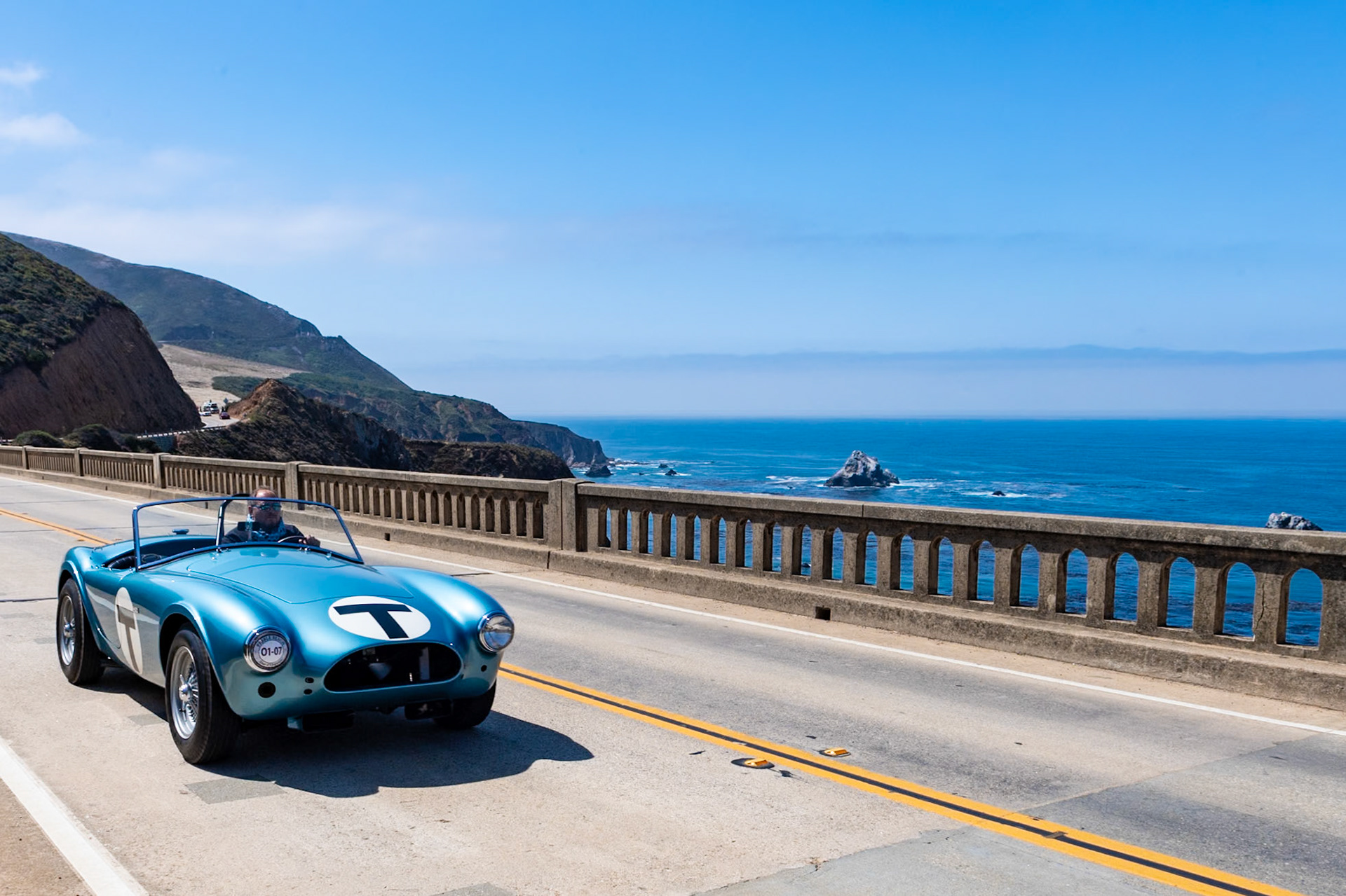 This car (chassis CSX 2005) is the fifth Cobra built; the AC factory listed its build date as July 17, 1962, and it was invoiced to Shelby American that September. It was featured in the 1964 film The Killers, a Universal Studios production based in part on a short story by Ernest Hemingway and starring Lee Marvin, Angie Dickinson, Ronald Reagan and John Cassavetes. In 1964 it was sent to the newly opened Carroll Shelby School of High Performance Driving at Riverside Raceway, where it was driven by many aspiring celebrity race drivers, including Steve McQueen and James Garner as well as a Miss Universe. Here the Roadster is presented in its school uniform of light blue metallic paint complete with its distinctive large letter T for Trainer. Its original body panels and hand-stamped and numbered fittings have all been restored to be exactly as the car was when running around Riverside Raceway.