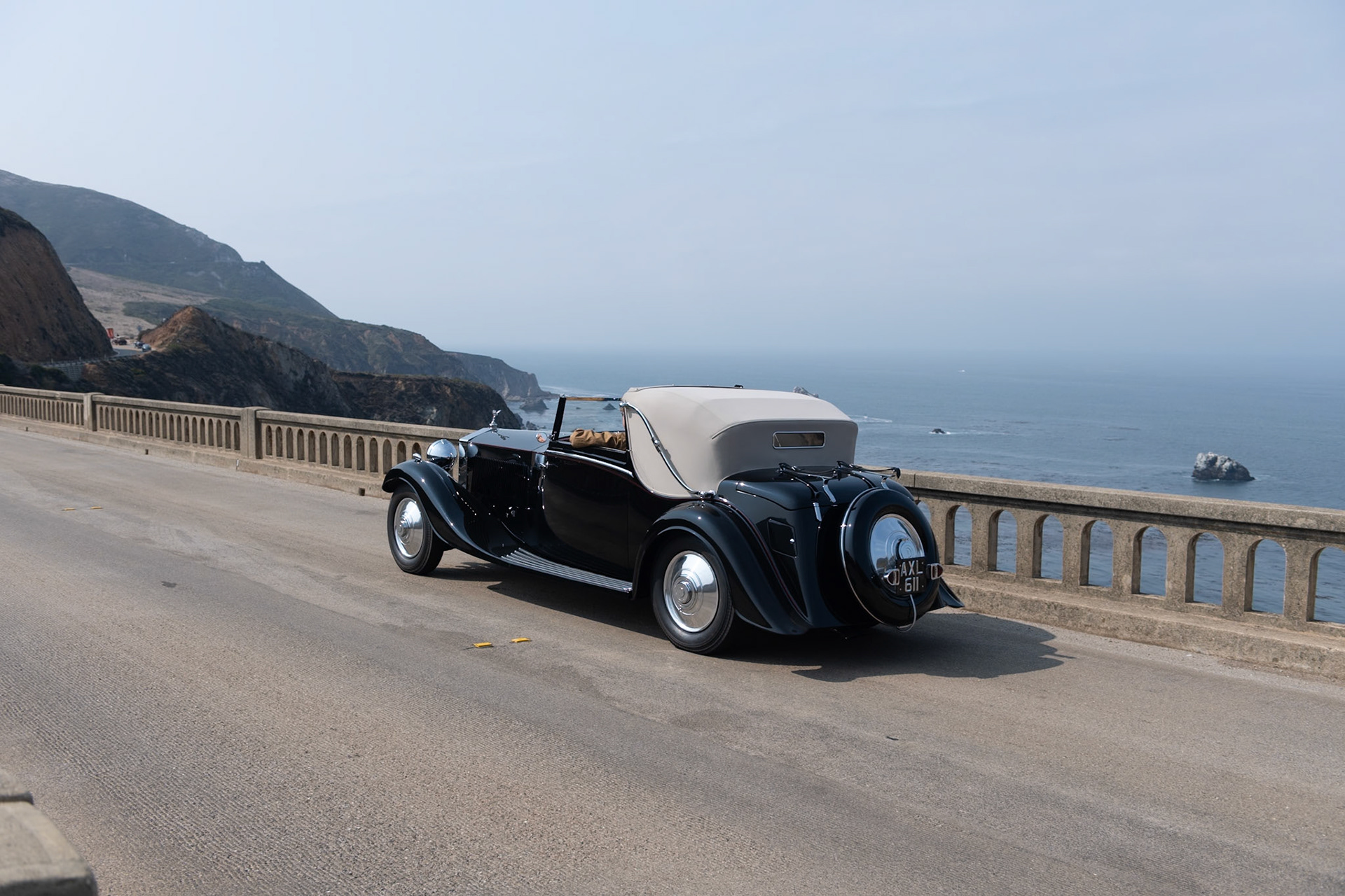 The Rolls-Royce Phantom II was the third and last of the Rolls-Royce 40/50 HP models, with an improved engine in an all-new and lower chassis. The engine was bolted directly to the 4-speed manual transmission, to which synchromesh was added after 1932. The Phantom II was designed with a 150-inch chassis, but a revised prototype was built on a 6-inch-shorter “Continental” chassis in 1930 and shown at the Biarritz Grand Concours d’Elegance, where it was awarded the Grand Prix d’Honneur. This car was the first of the PII Continental models, which proved popular with more adventurous drivers. This Phantom II (chassis 104PY) features a desirable 3-position Drophead Coupé body by H. J. Mulliner &amp; Co. Ordered by its first owner for long trips to Europe, it came to the United States in 1958. Its current owner acquired the car in 2016 and commissioned a full restoration.