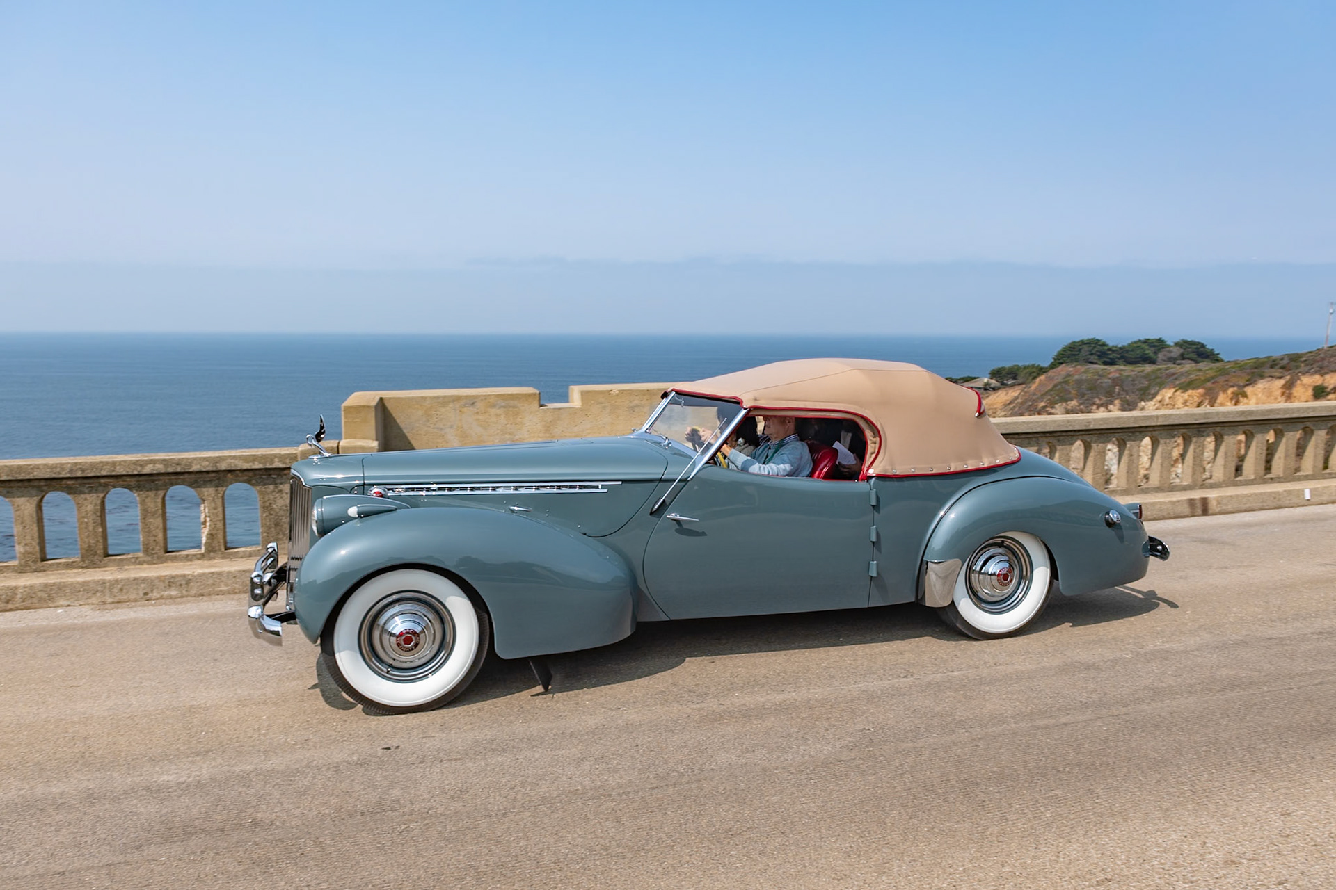 The Packard Super Eight was the larger of the two 8-cylinder models produced in 1940, and its 356-cubic-inch, straight-8 engine benefitted from an overdrive gearbox that made the cars perfect for high speed touring. The Custom Super Eight 180 can be identified by its distinctive hubcaps and hood louvers along the sides. The custom body era was drawing to a close by 1940, but Packard catalogs continued to offer several body styles, including a Club Sedan as well as this Darrin-bodied Convertible Victoria that, as with many of Howard “Dutch” Darrin’s designs, were often created for Hollywood celebrities. The first owner of this Convertible Victoria kept it in very original condition for nearly fifty years. The current owners bought it in 2014 and restored it, and this is the restored car’s first public appearance.