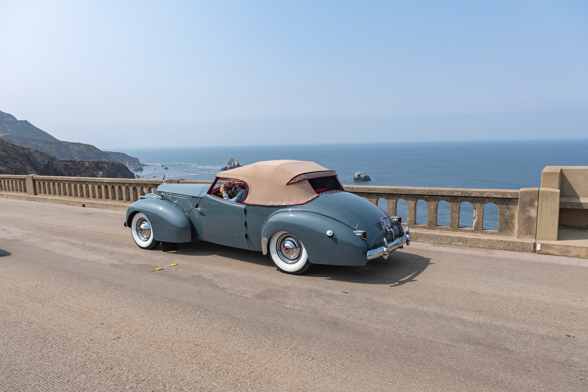 The Packard Super Eight was the larger of the two 8-cylinder models produced in 1940, and its 356-cubic-inch, straight-8 engine benefitted from an overdrive gearbox that made the cars perfect for high speed touring. The Custom Super Eight 180 can be identified by its distinctive hubcaps and hood louvers along the sides. The custom body era was drawing to a close by 1940, but Packard catalogs continued to offer several body styles, including a Club Sedan as well as this Darrin-bodied Convertible Victoria that, as with many of Howard “Dutch” Darrin’s designs, were often created for Hollywood celebrities. The first owner of this Convertible Victoria kept it in very original condition for nearly fifty years. The current owners bought it in 2014 and restored it, and this is the restored car’s first public appearance.