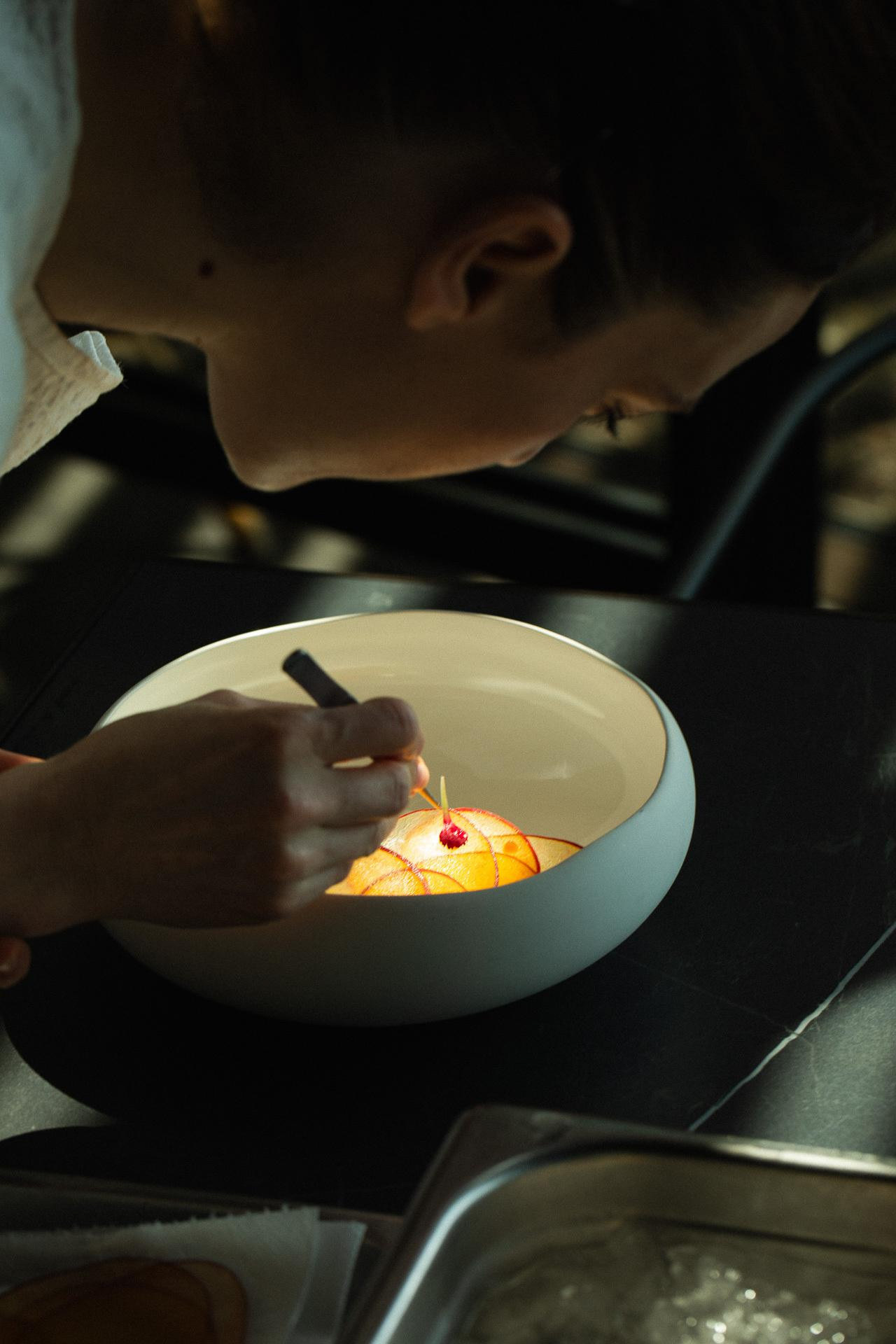 Croatian pastry chef Maša Salopek plating a fine-dining dessert in a professional kitchen