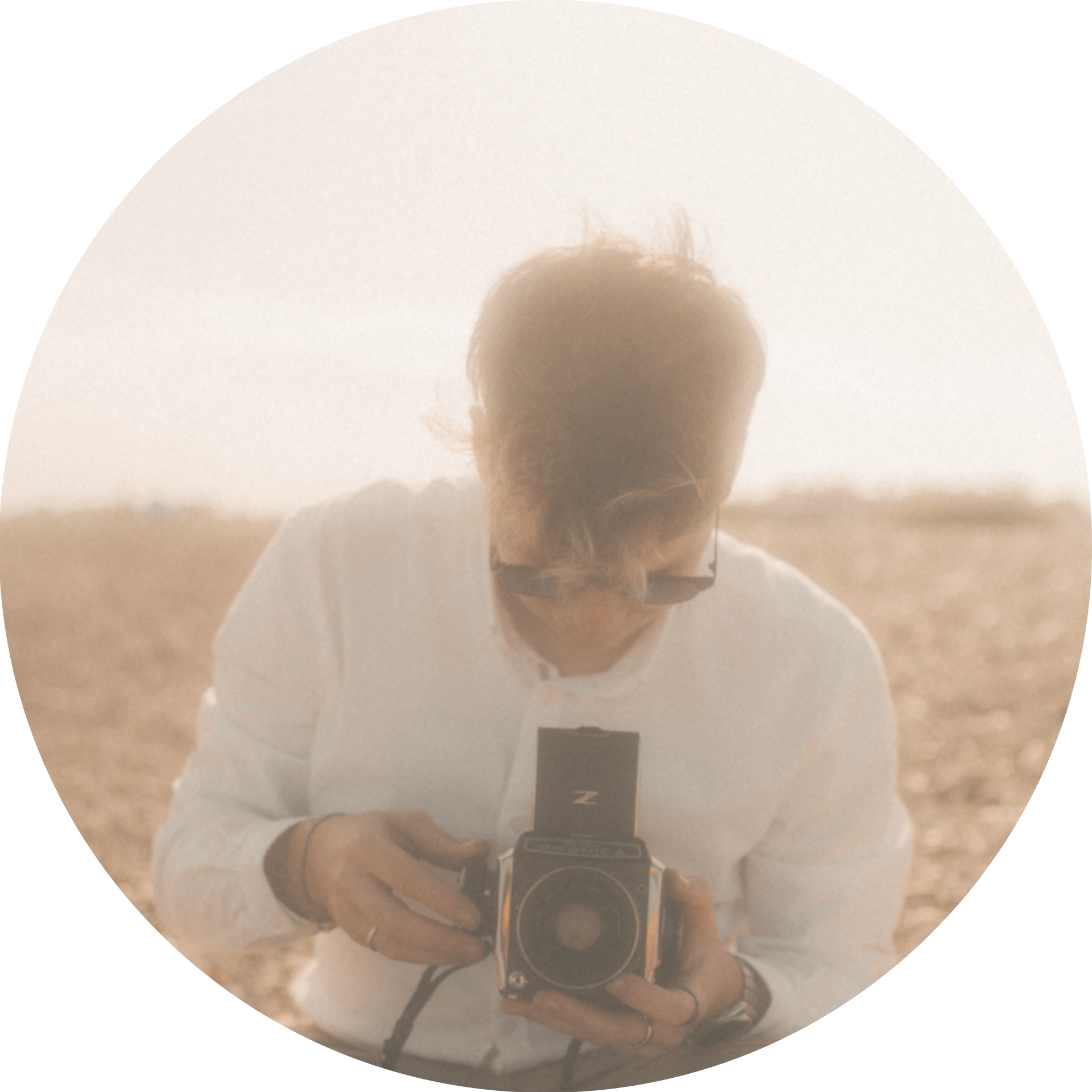 An icon image showing Tom looking through the viewfinder of a vintage medium format camera.