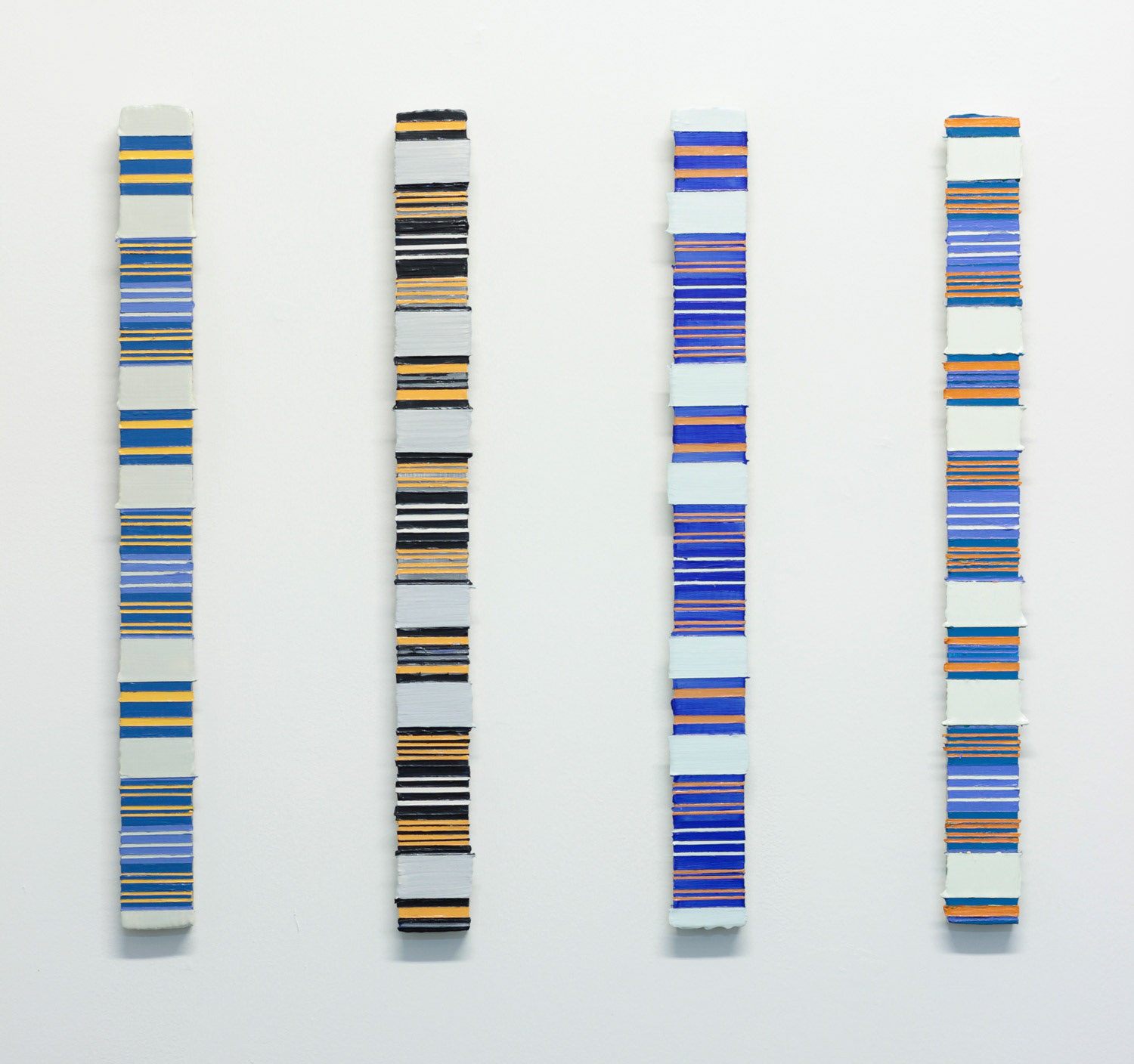 four lengths of wood painted with lines on a white wall
