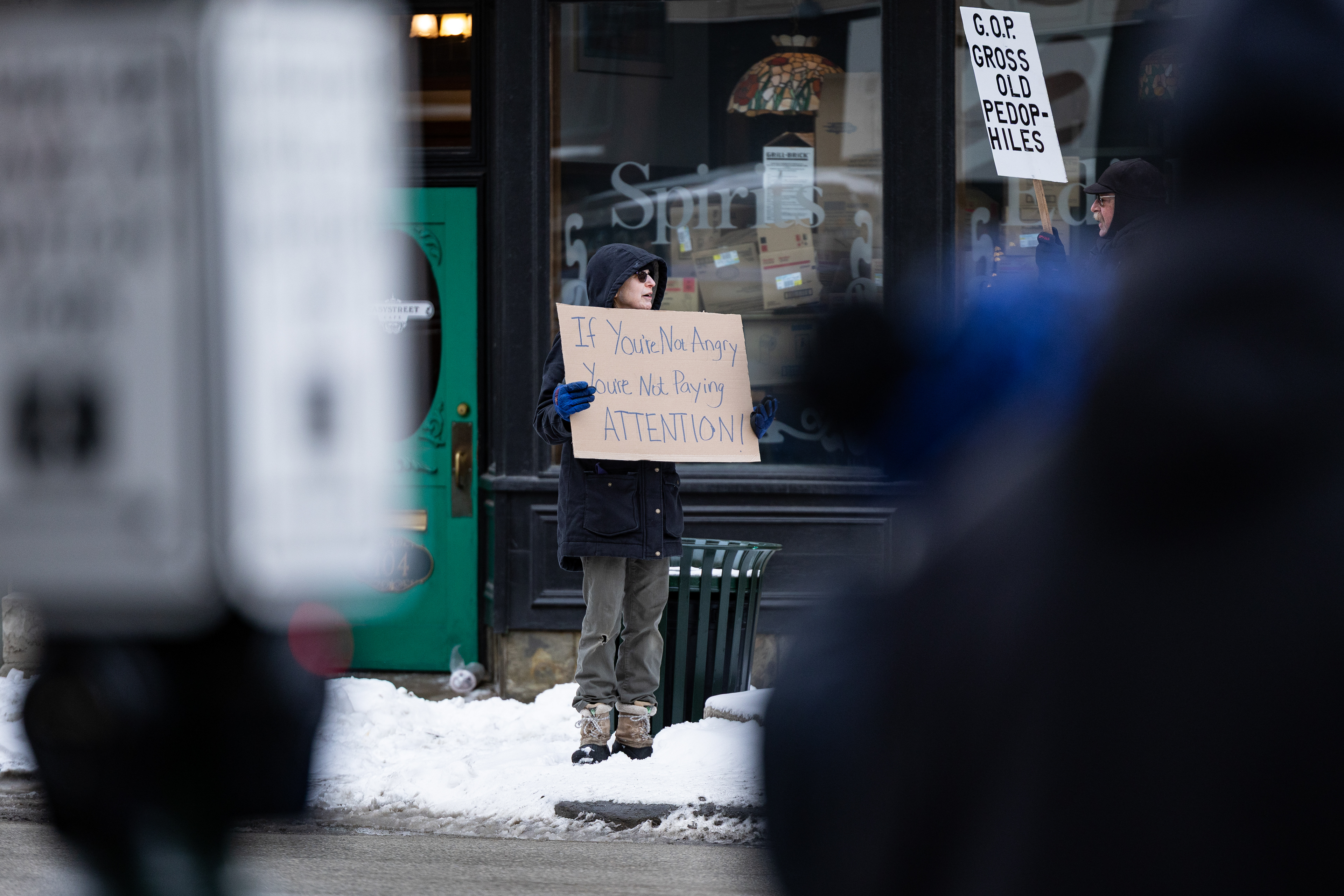 BOWLING GREEN, OH - A protestor stands on the corner of E. Main and Wooster Street holding a sign, protesting recent events, in Bowling Green, Ohio.