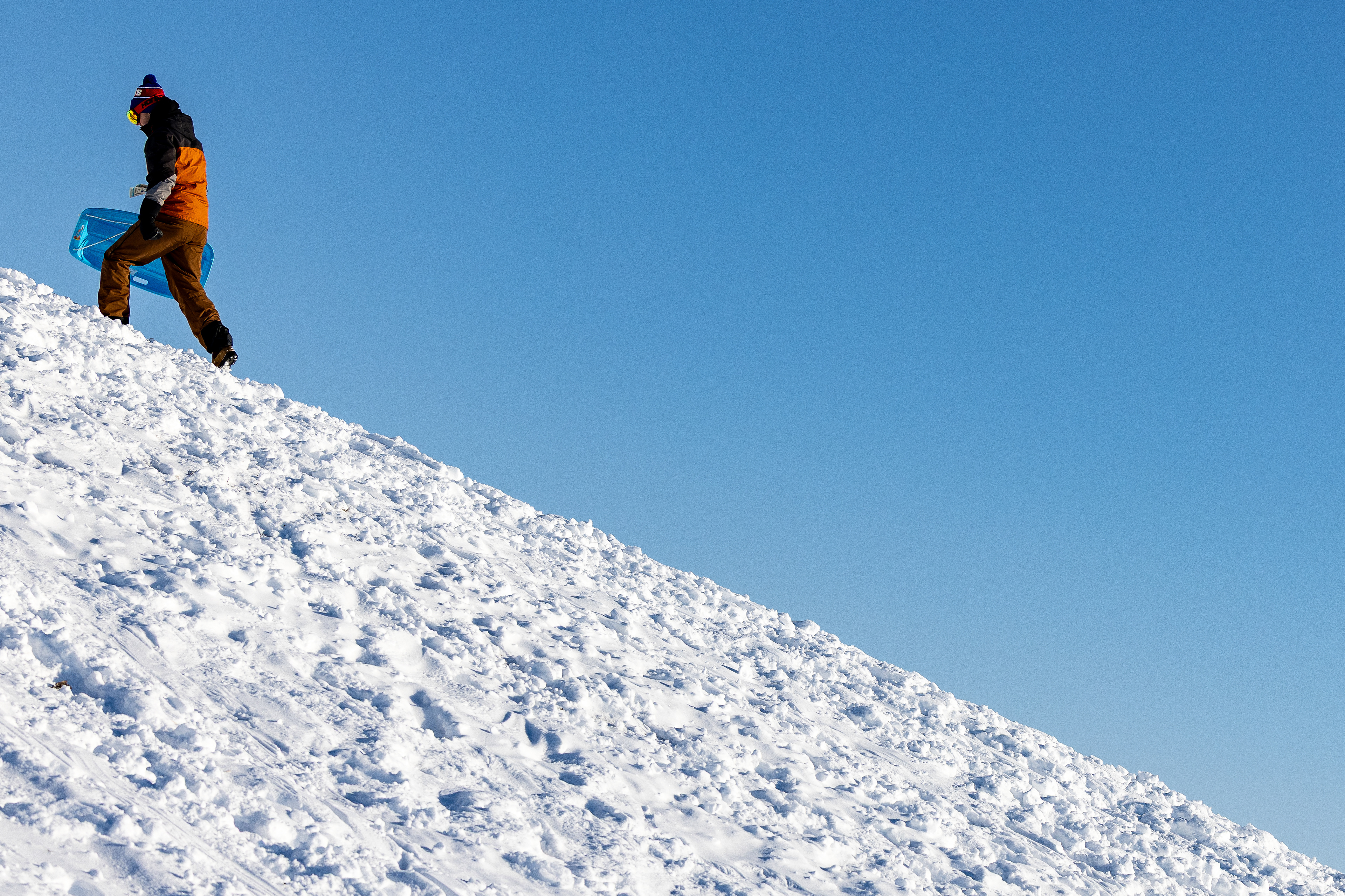 BOWLING GREEN, OH - A student walks up Mt. Jerome carrying a sled following snowfall, in Bowling Green, Ohio. 