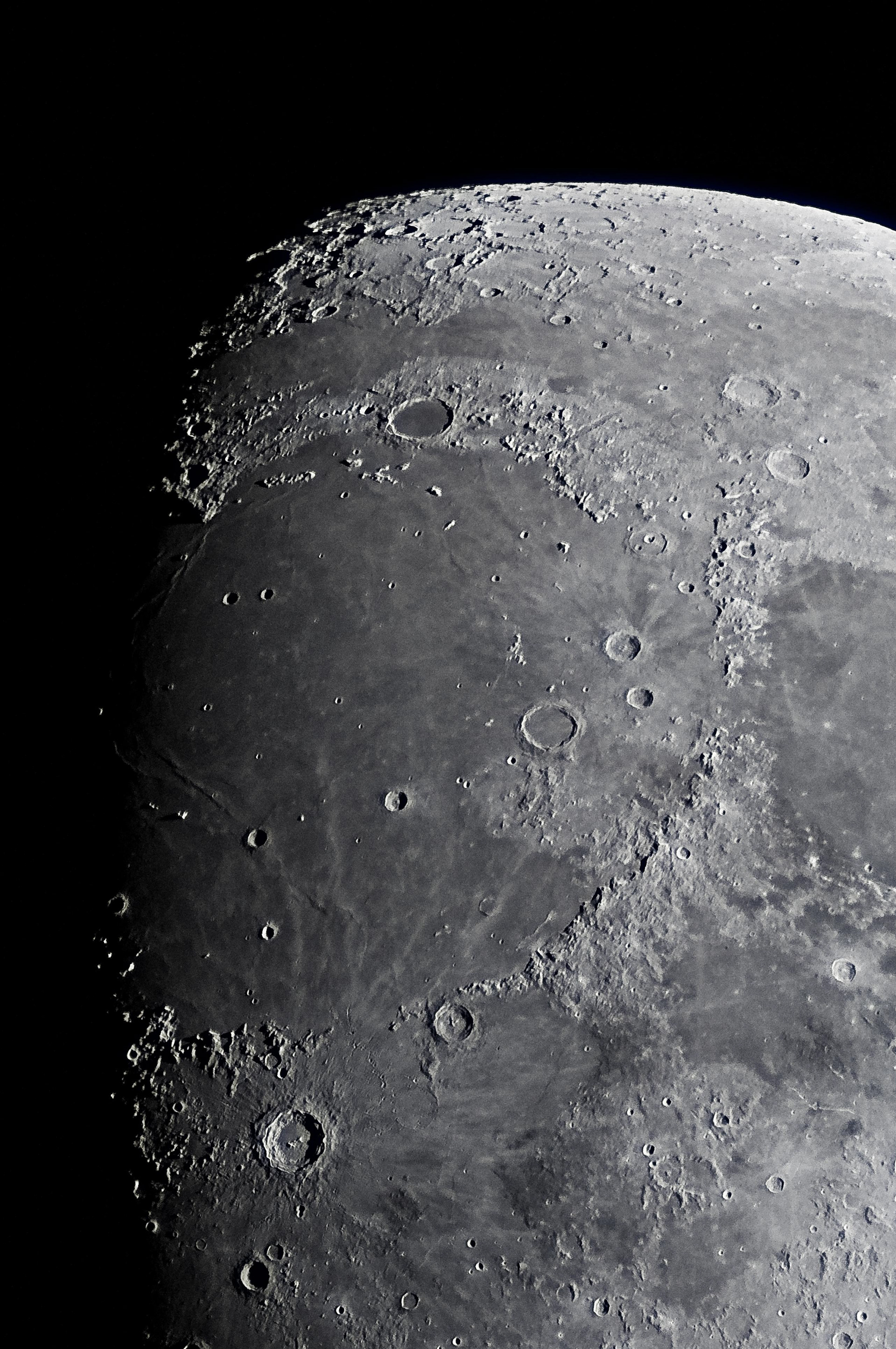 Mare Imbrium (Sea of Rains) - With a diameter of over 1100 km, the Sea of Rains is the Moon’s largest impact basin and the second largest among lunar maria. Its formation followed a cataclysmic impact from the Late Heavy Bombardment roughly 4 billion years ago. Radioisotopic dating put its age between 3.7 and 3.9 billion years. Bordering Mare Imbrium are concentric mountain ranges reaching up to 7 km high, which are material excavated from the original impact.  The basin’s northern region is confined by the Jura-Gebirge Mountains, which are divided by the 110 km-wide Plato Crater. The Alps (lunar, not French) trace along the northeastern border, and come to an end angling southward. Between the Seas of Rains and Serenity (far right of center), the Caucasus Mountain range leads into an open patch of mare that joins the two seas. 60 km due south, the vast Appenine mountains extend downward to the basin’s southern edge.  The large eye-catching crater south of Mare Imbrium is Copernicus, named after the 15th/16th century Polish astronomer, who revolutionized our solar system’s paradigm by placing the Sun at its center.