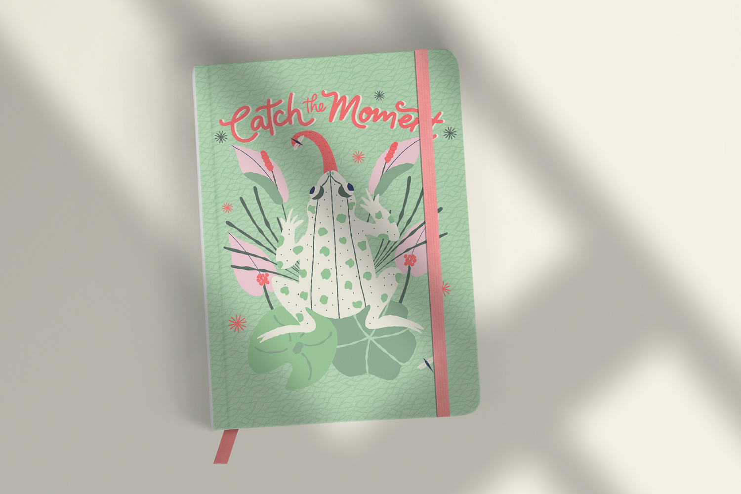 Catch the Moment hand lettered frog on lily pads in Mint Green on notebook mockup by Mabel Chow,licensable surface design