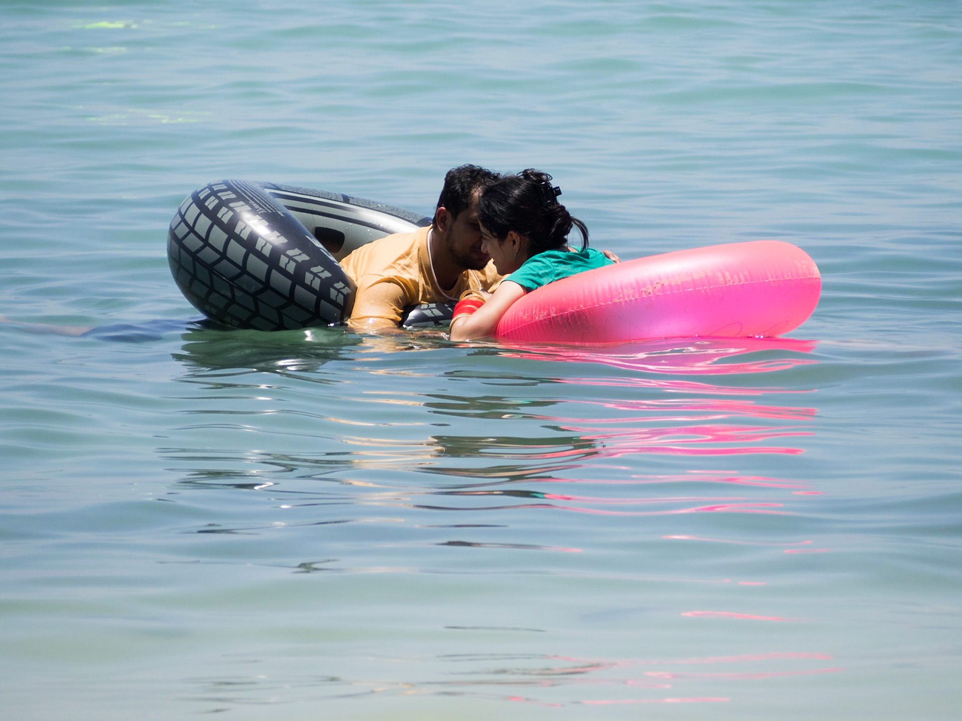 Indian couple in pool floats in the sea