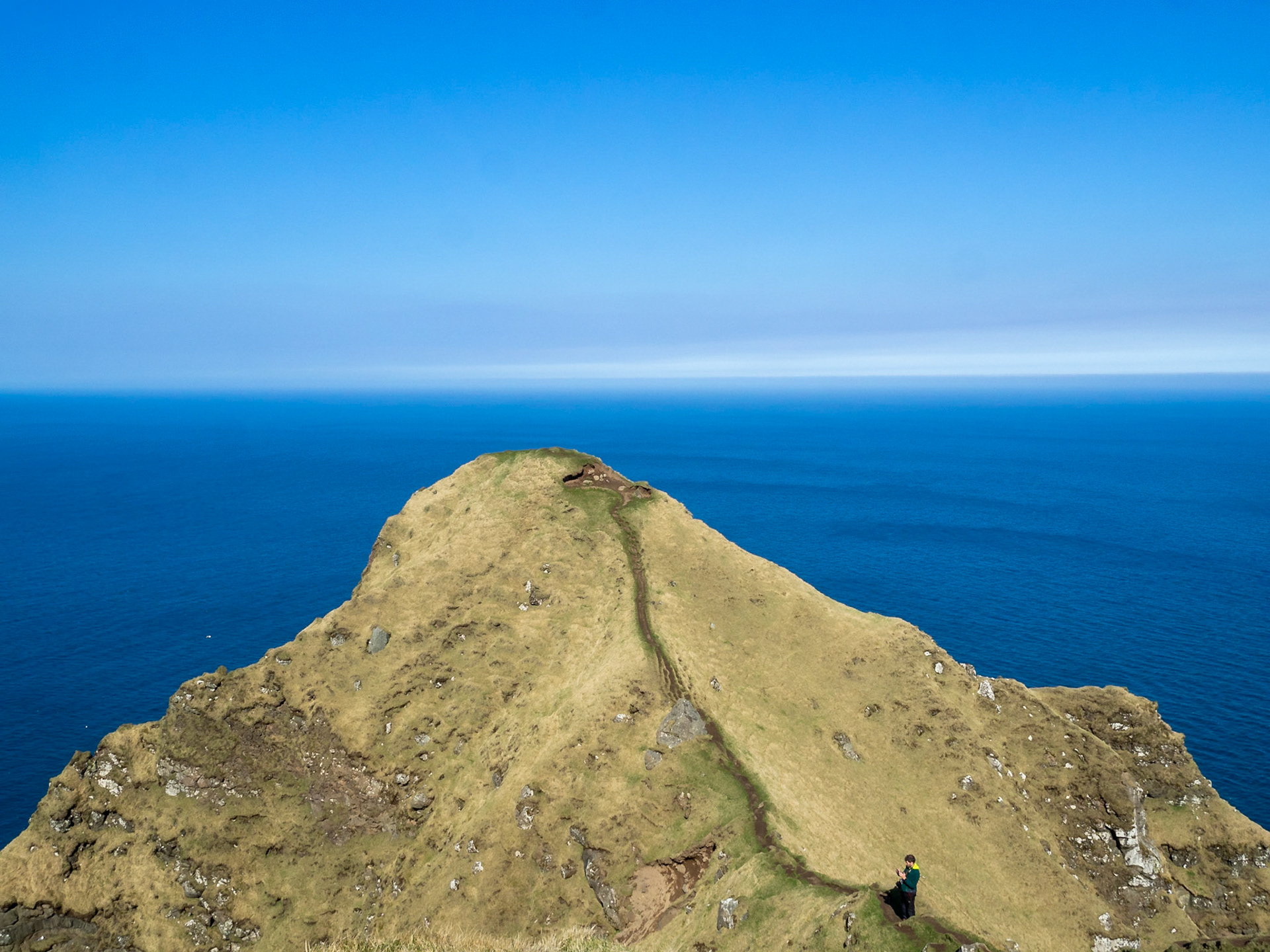 Taking pictures at the end of Kallur lighthouse hiking path in north Kalsoy island