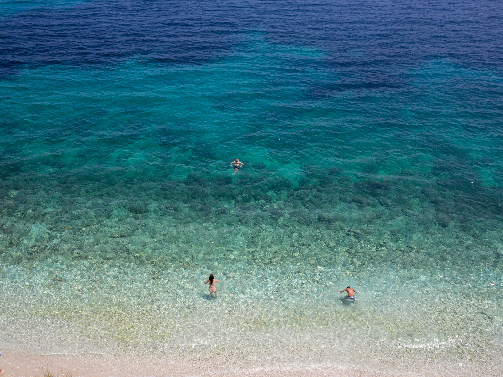 Up down view of people bathing in the turquoise waters of Cephalonia sea