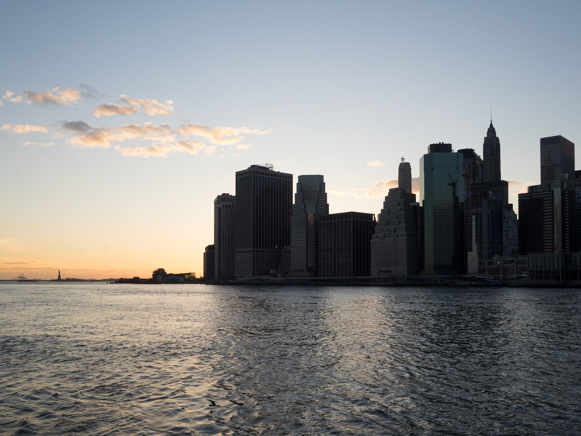 Manhattan skyline silhouette seen from Brooklyn against the sunset sky